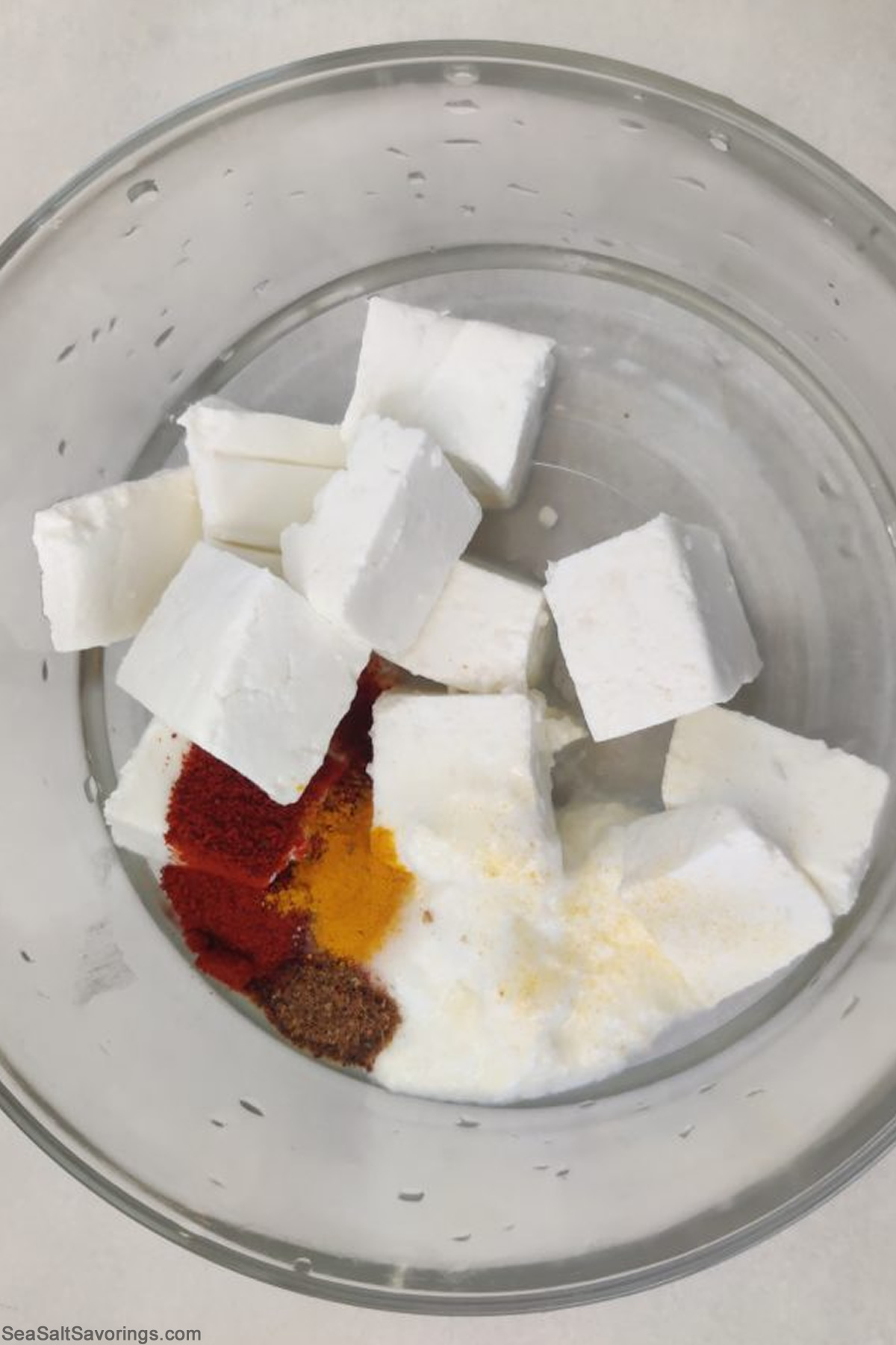 paneer cubes in a bowl with seasoning