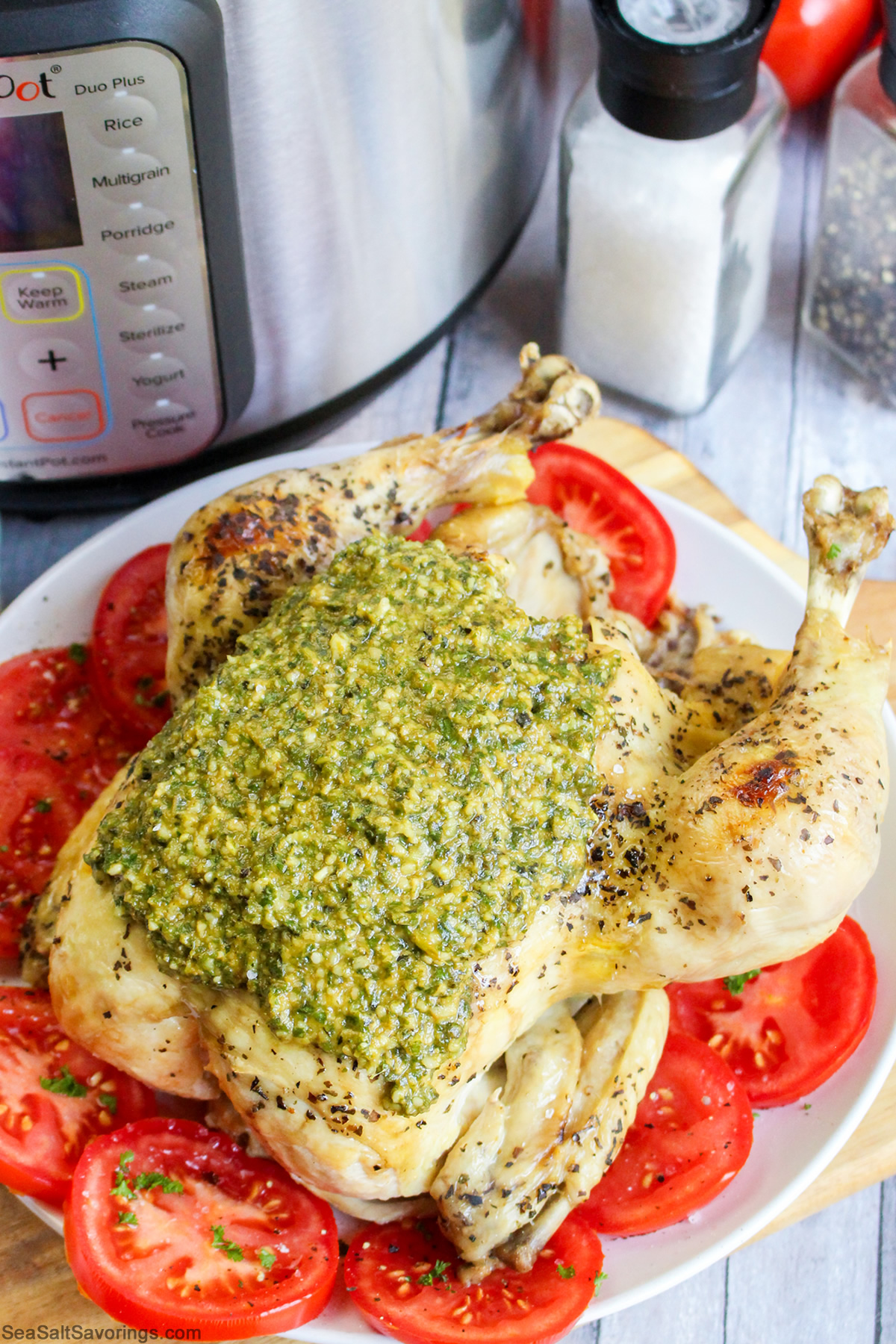 a whole roasted chicken with pesto sauce on top