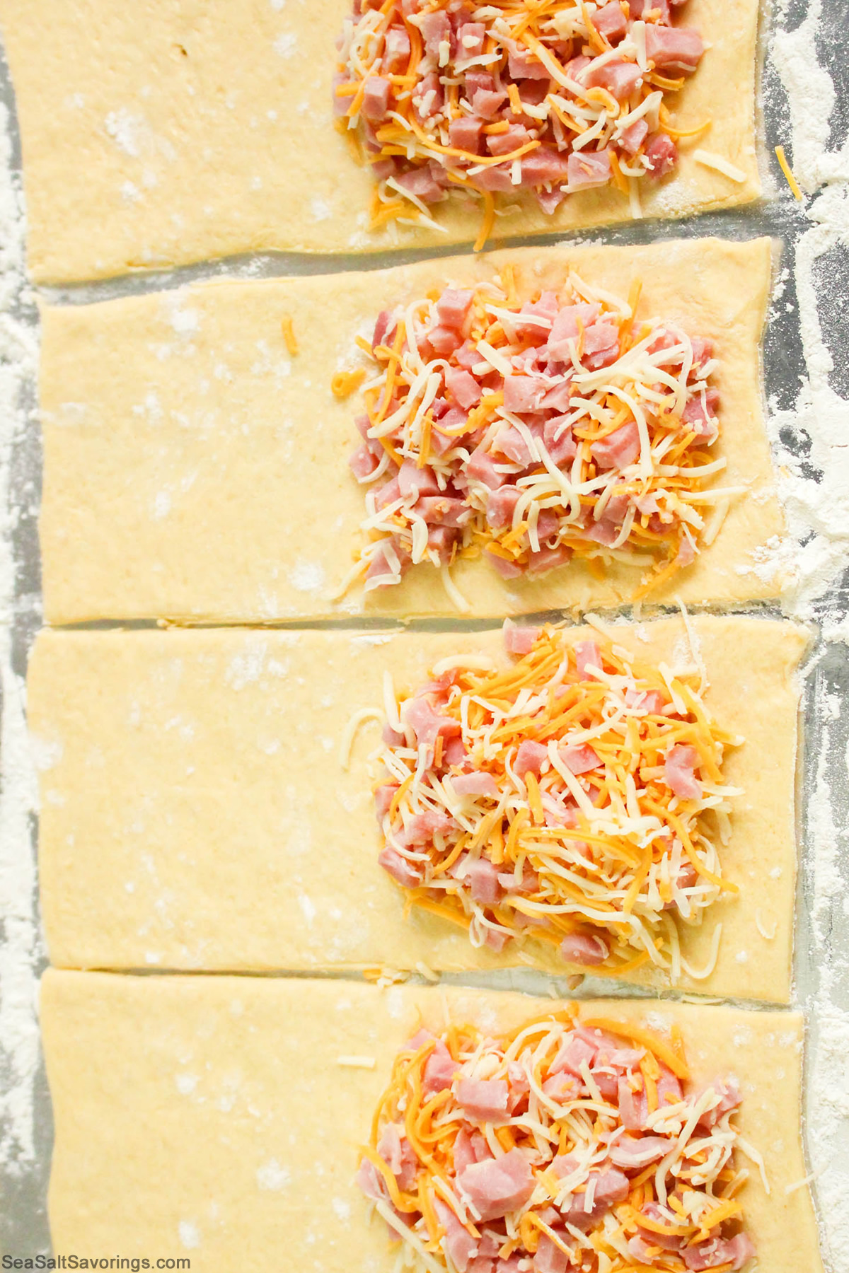 dough spread on cookie sheet with filling added on one side