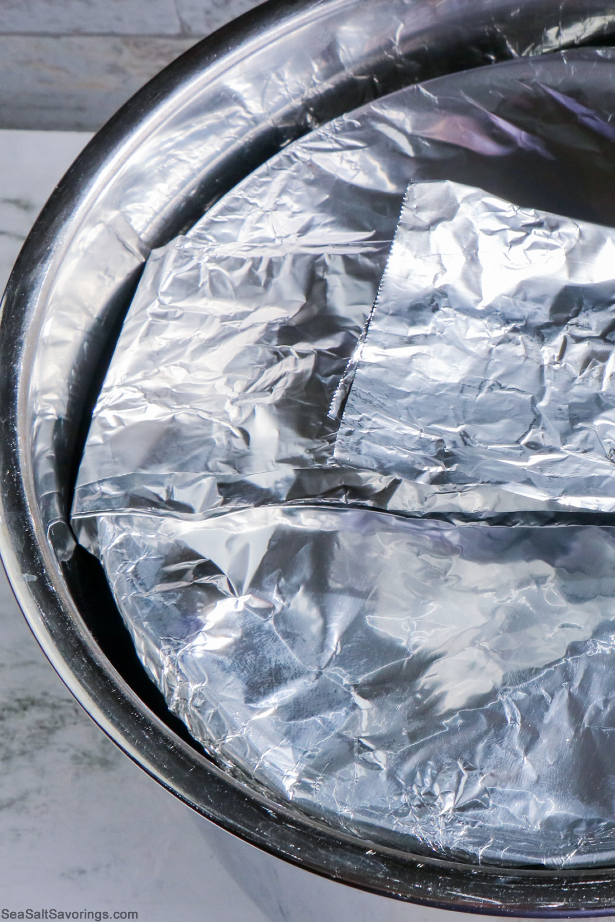 detailed view of the instant pot with the bread pudding baking dish all covered in foil