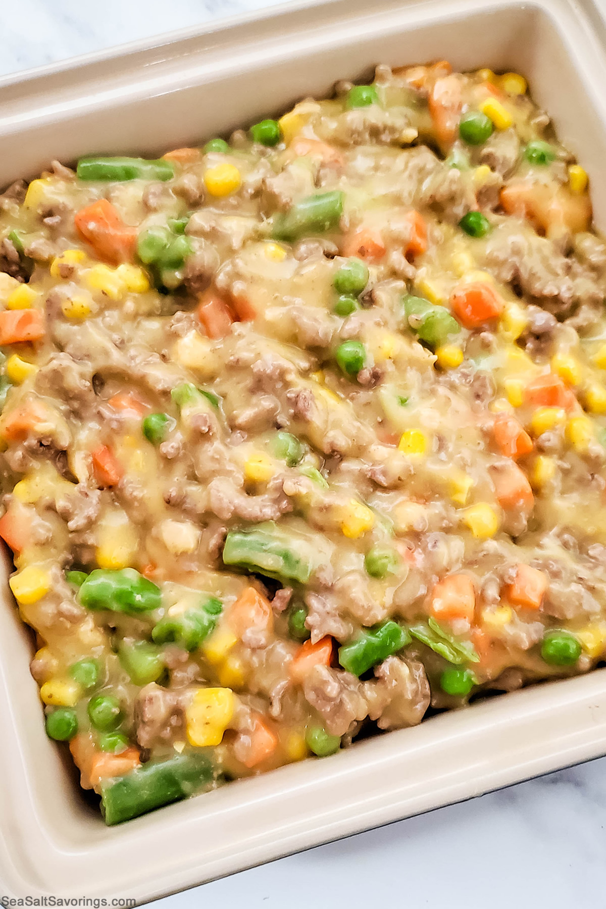 baking dish with first layer of shepherds pie filling added