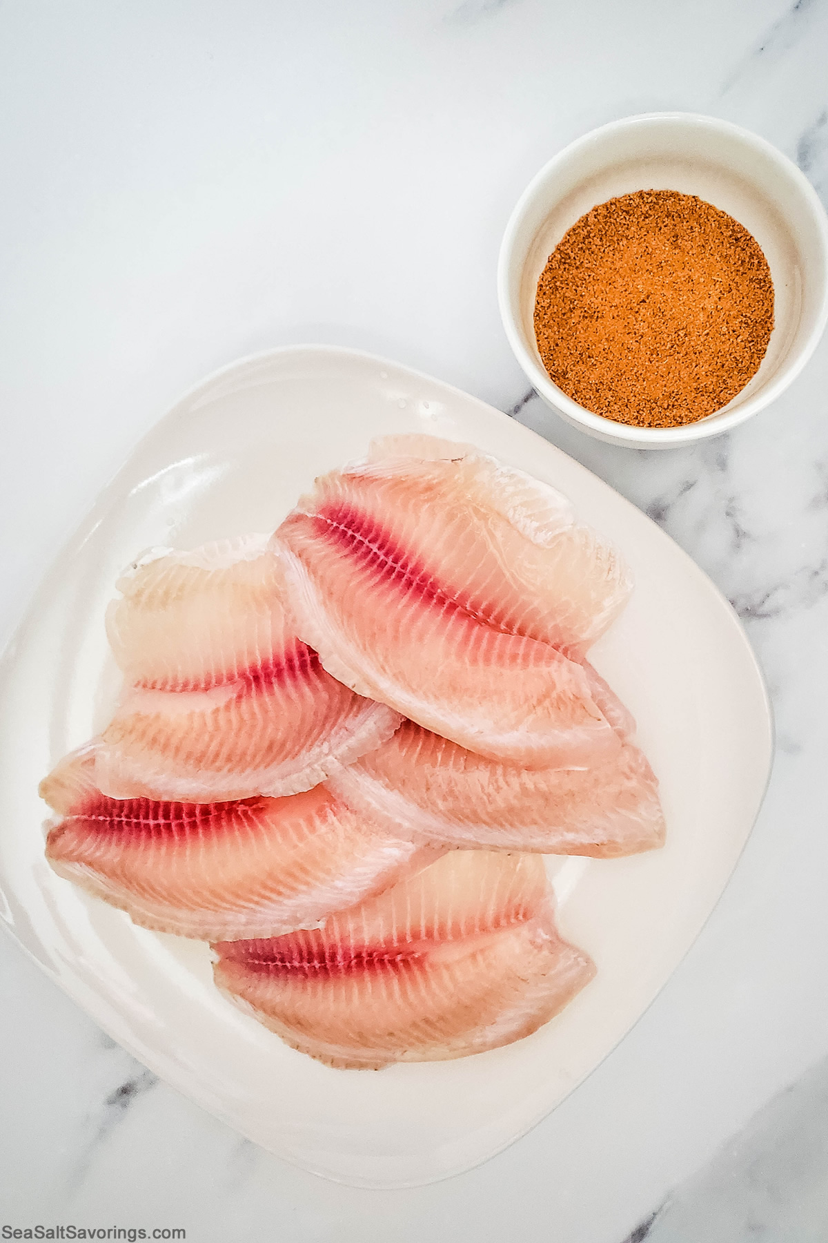 two simple ingredients for baked tilapia, the fish and season