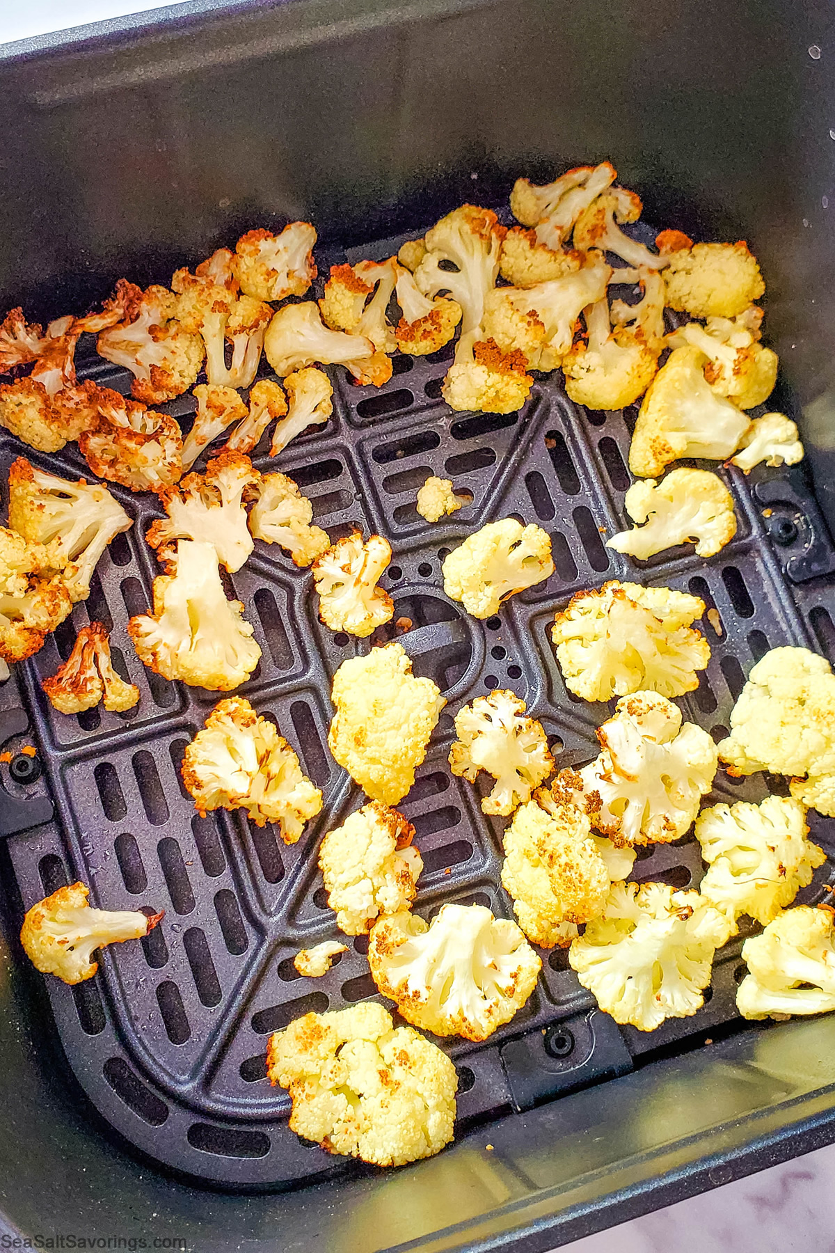 air fry basket with cauliflowers crispied