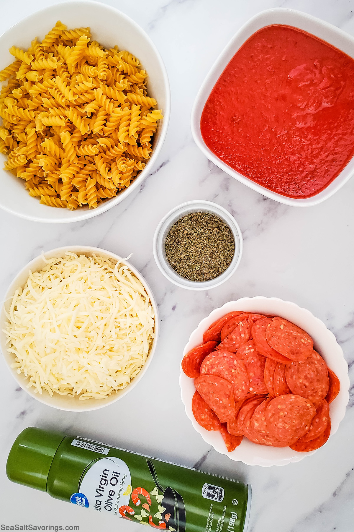 simple ingredients for pizza casserole featuring cheese and noodles and sauce and pepperoni and season