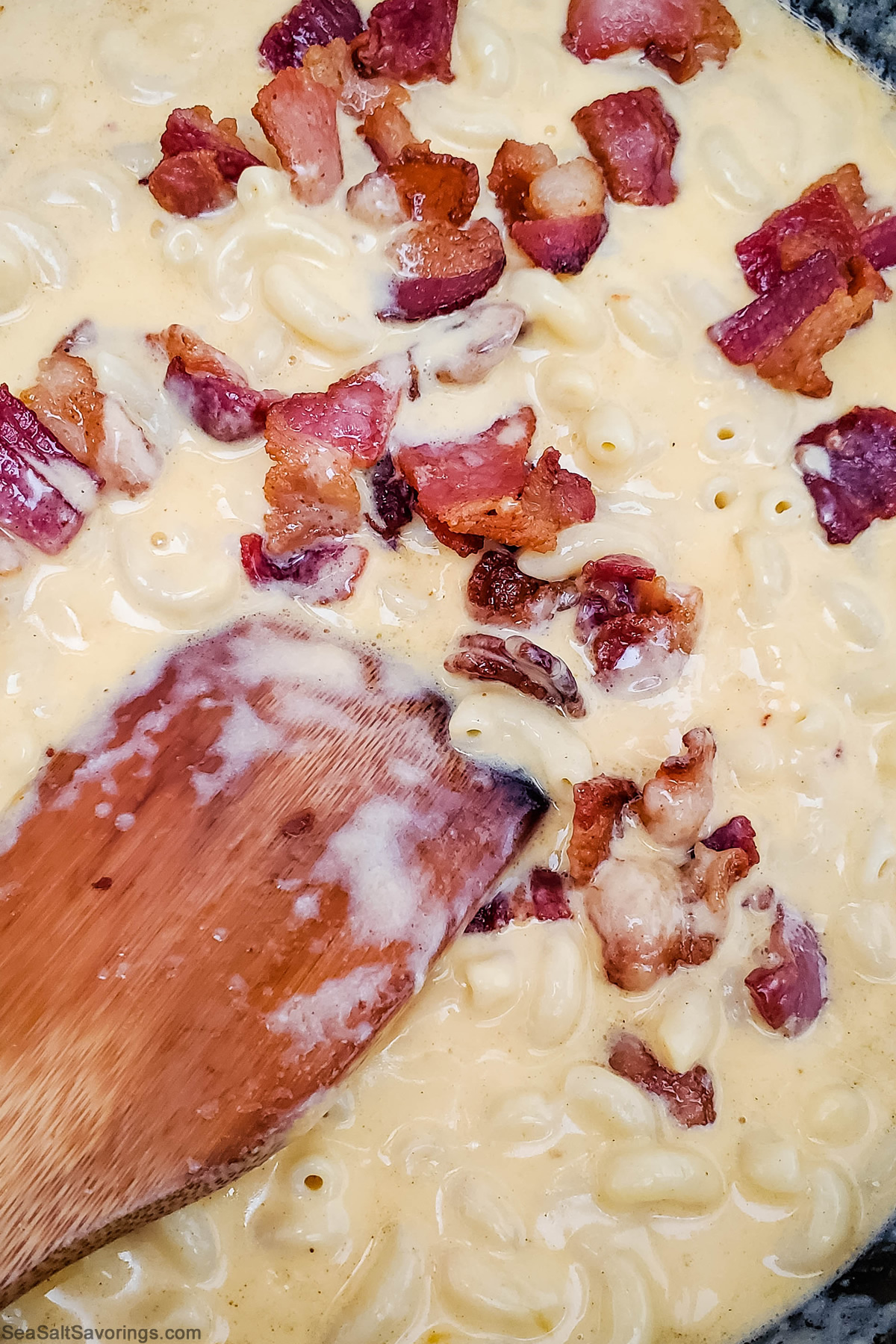 mixing crispy bacon chunks into mac and cheese