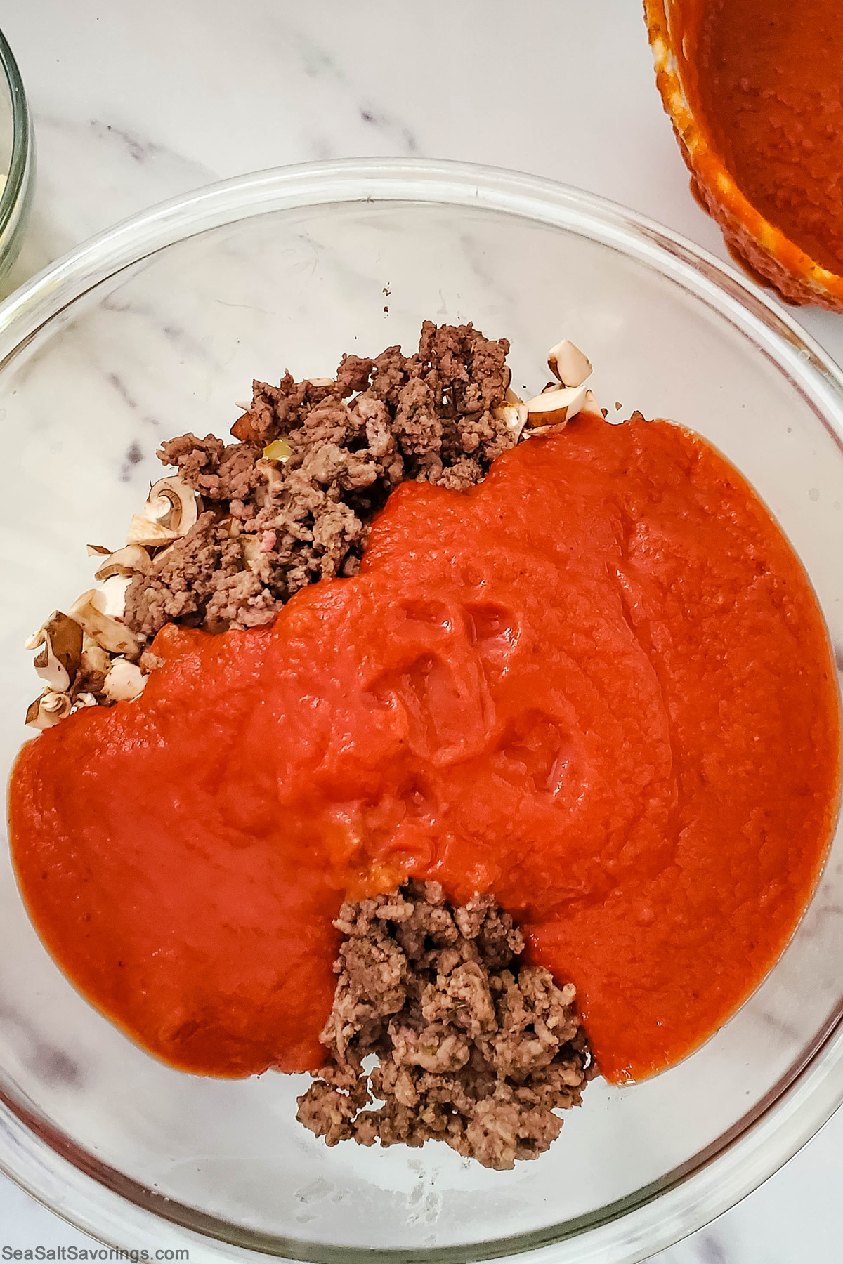 beef and sauce and mushrooms in a bowl ready to mix