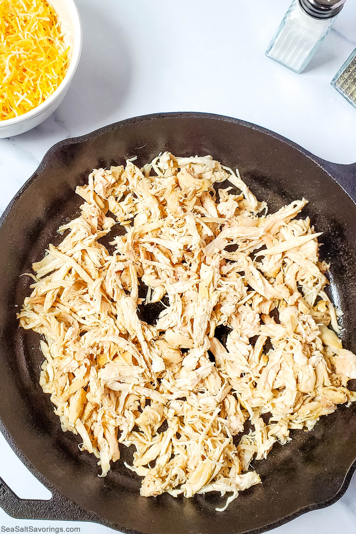 shredded chicken at the bottom of the skillet