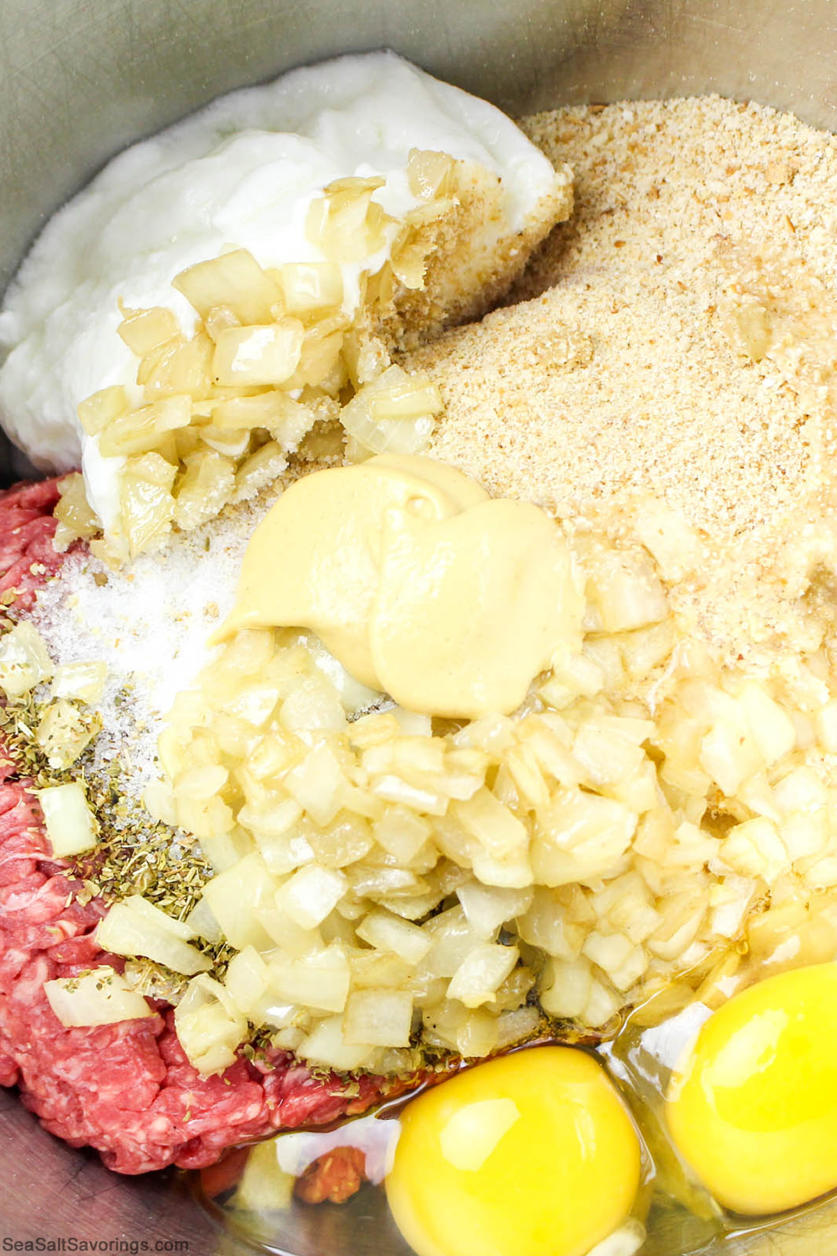 all meatloaf ingredients plopped into a bowl ready to be mixed