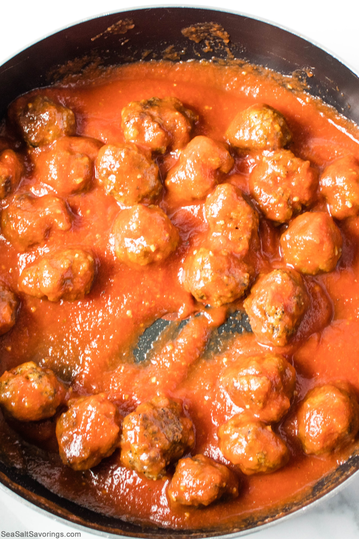 skillet of meatballs simmering in red sauce