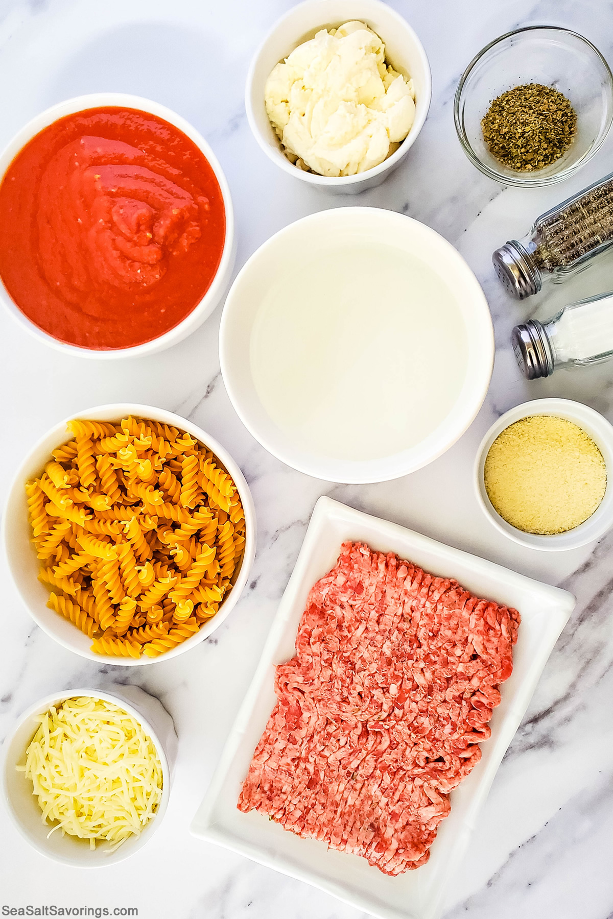 the simple ingredients for skillet lasagna placed in bowls on a table