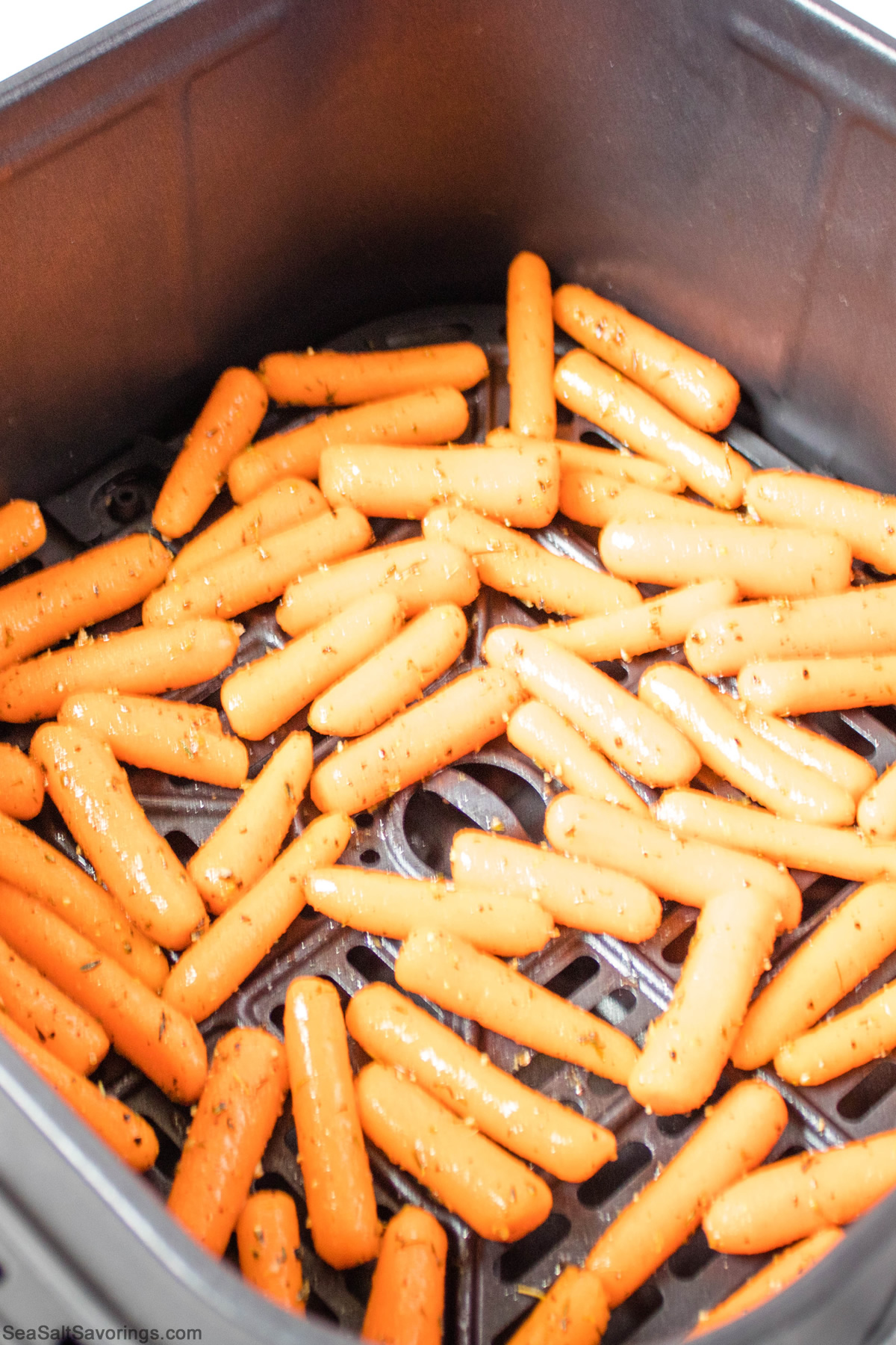 seasoned baby carrots carefully placed in air fry basket