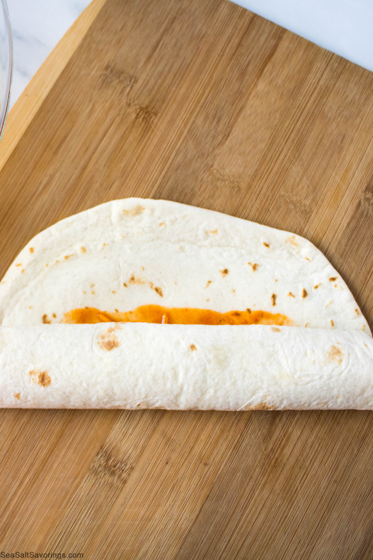 tortilla with filling getting rolled up