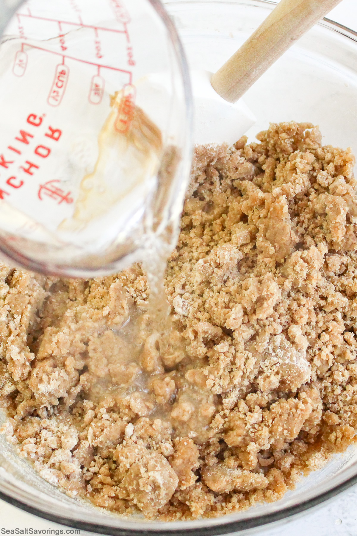 pouring liquid ingredients into dry ingredients in a mixing bowl