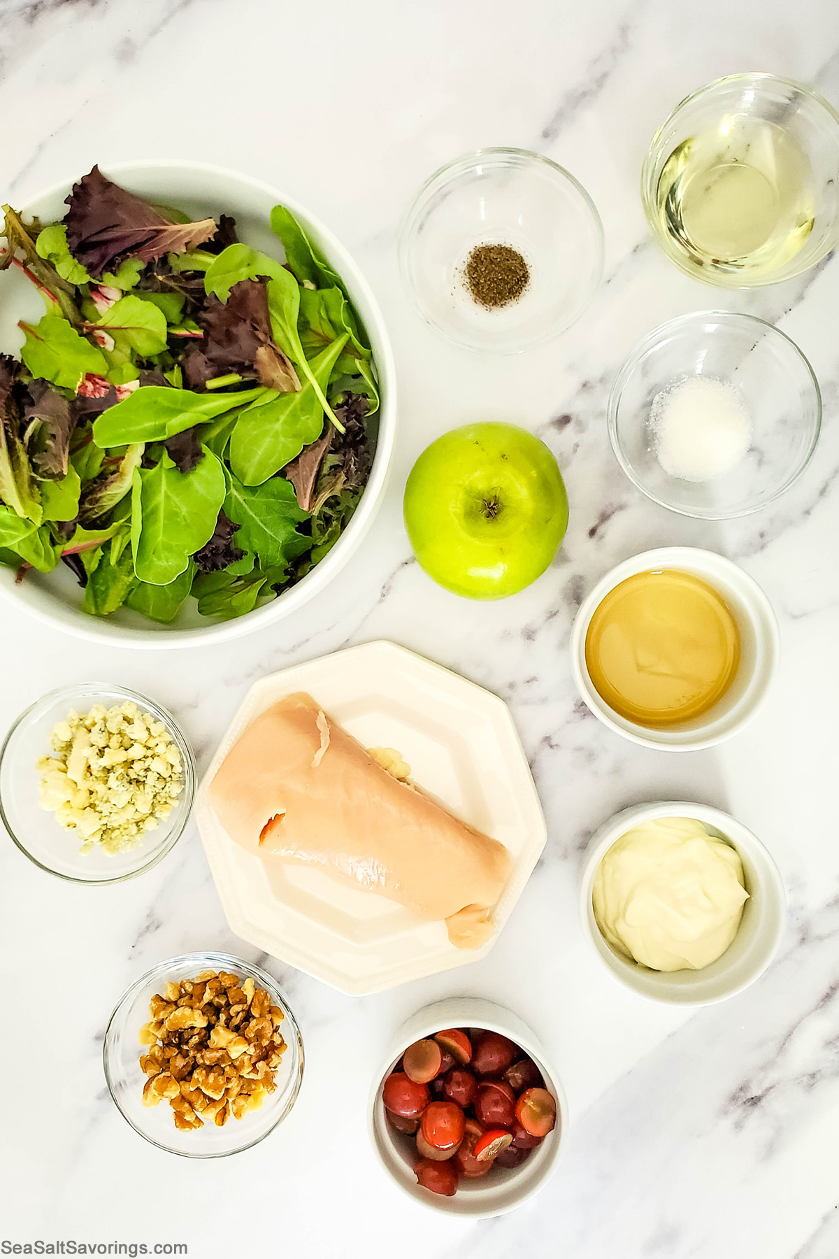 chicken apple salad ingredients in bowls on a table