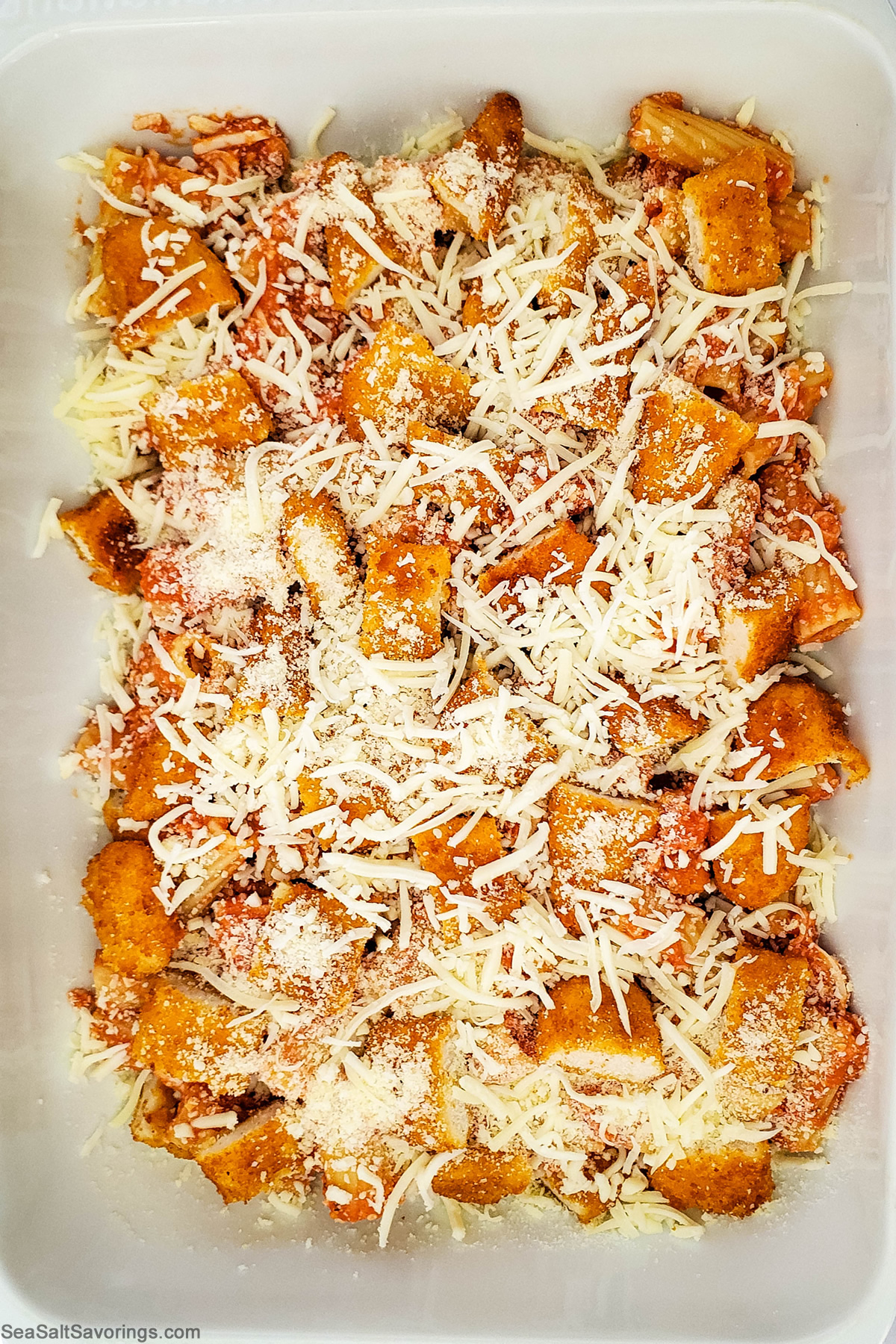 chicken parmesan mixture added to baking dish ready to cook