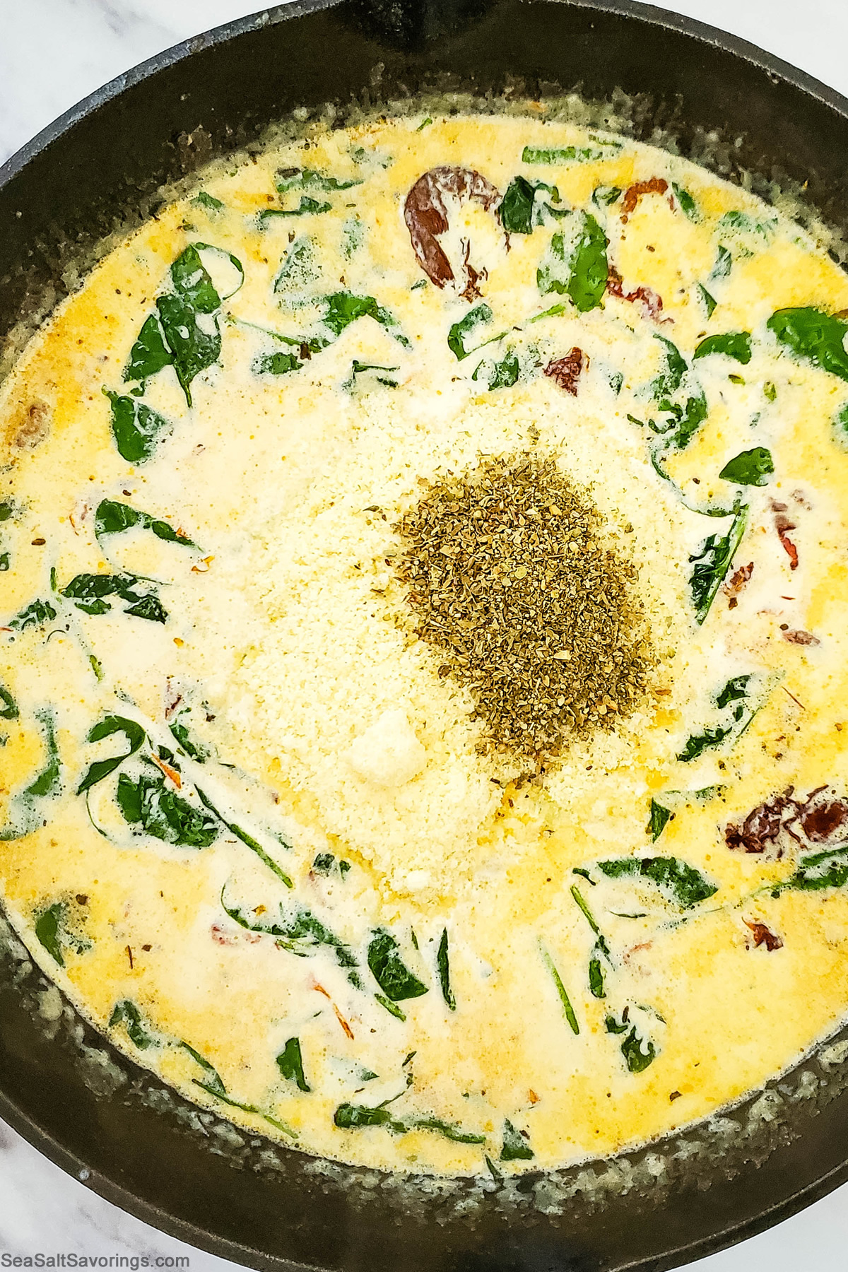 seasoning and cream base added to skillet