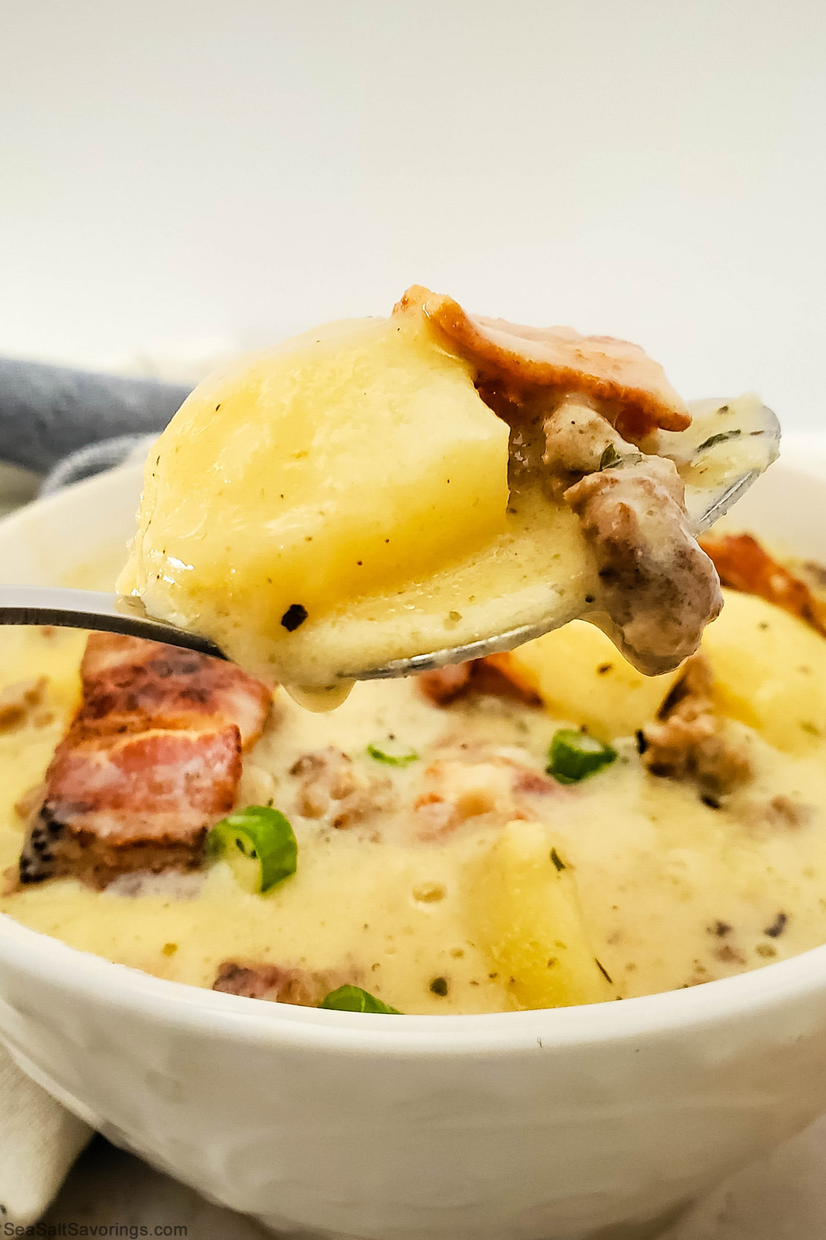 close up view of a spoon full of cheeseburger soup