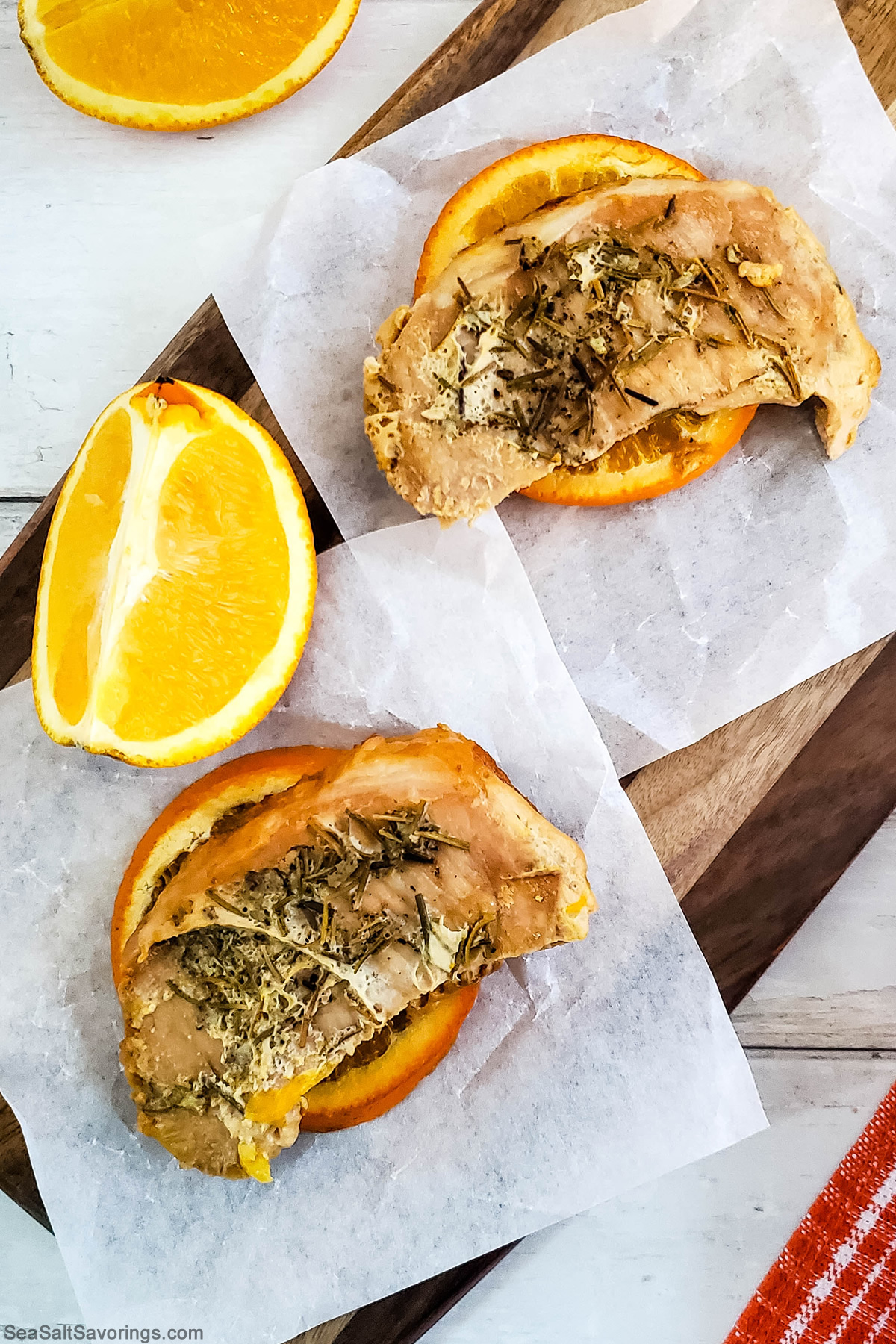 orange rosemary pork chops laying on orang slices