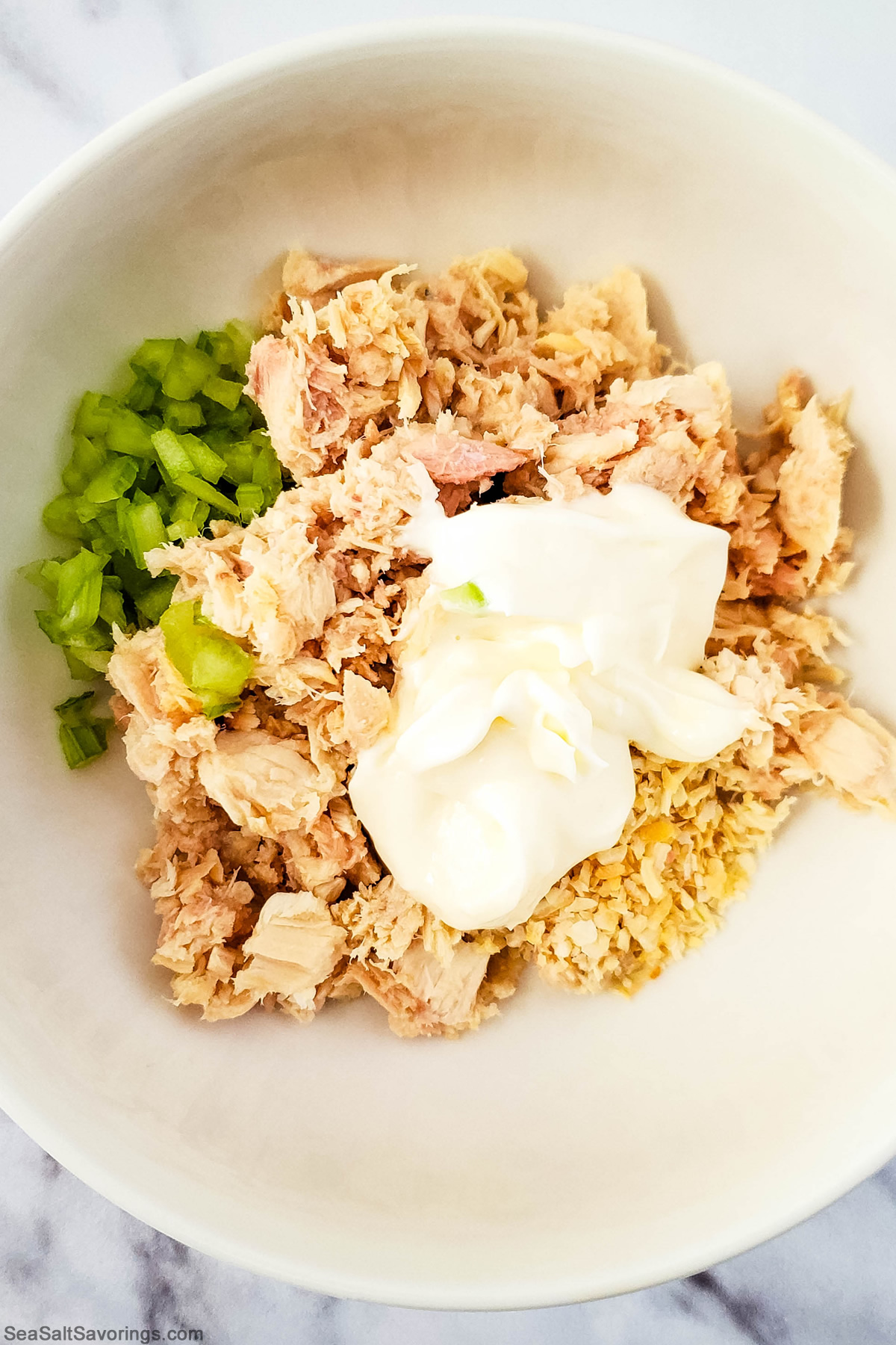 all ingredients added to a bowl to mix up for tuna melt filling