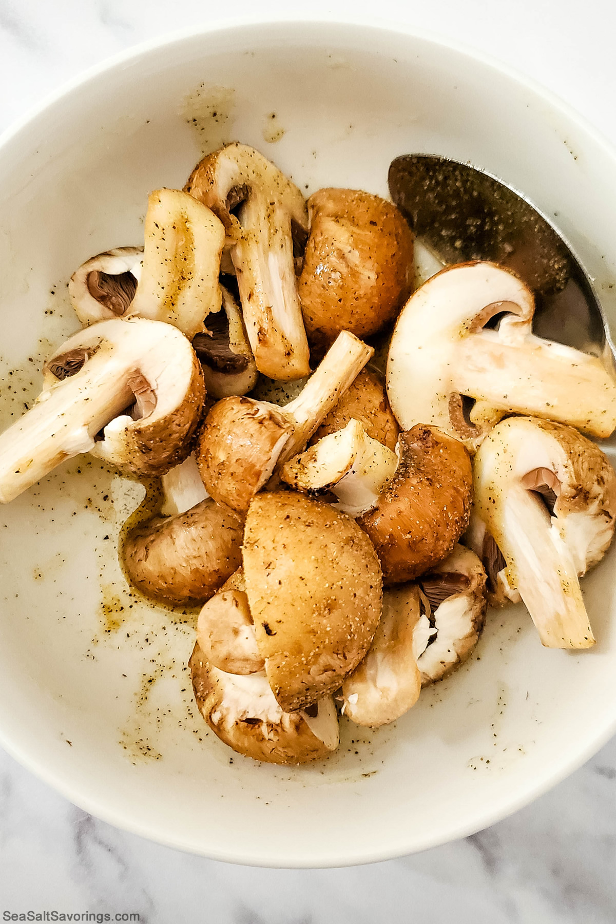 bowl of mushrooms oil and spices getting mixed