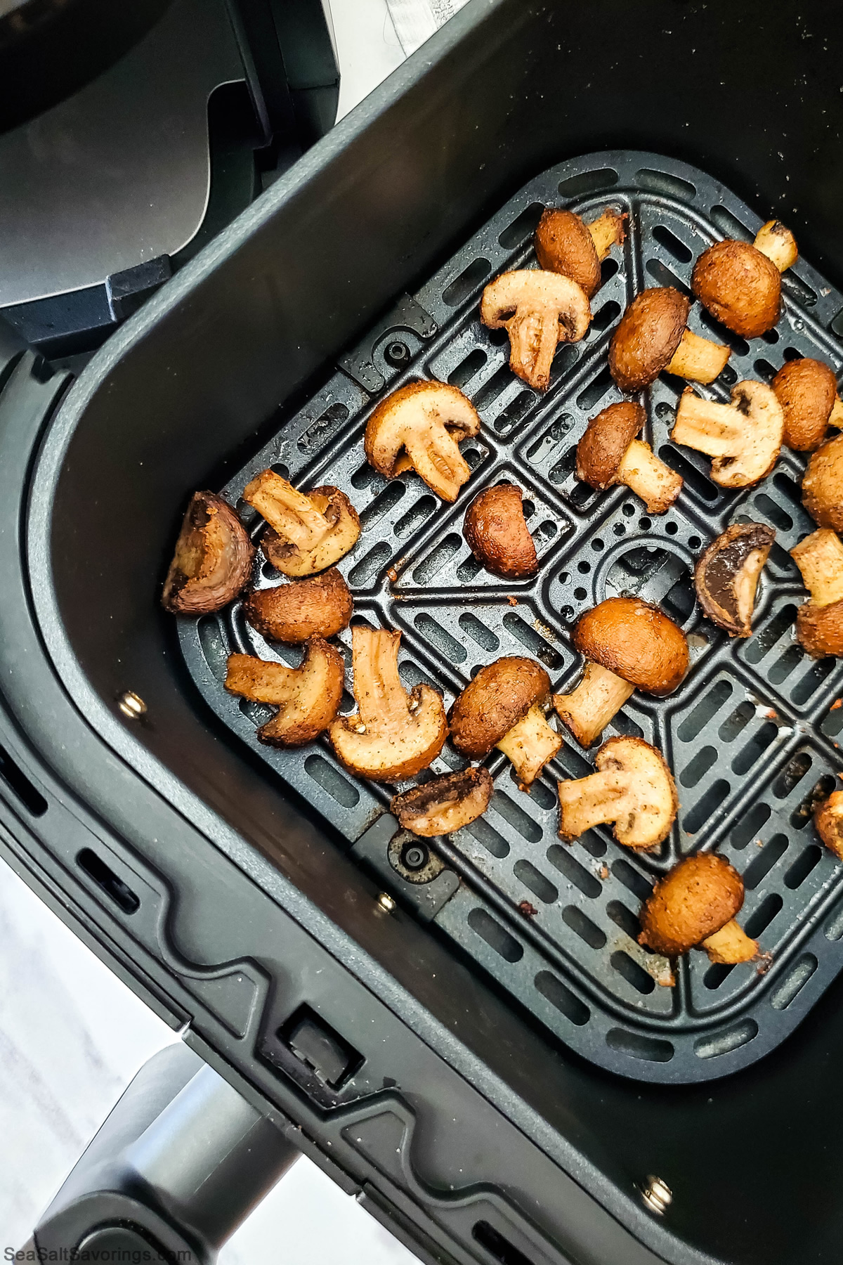 garlic mushrooms cooking in air fryer basket