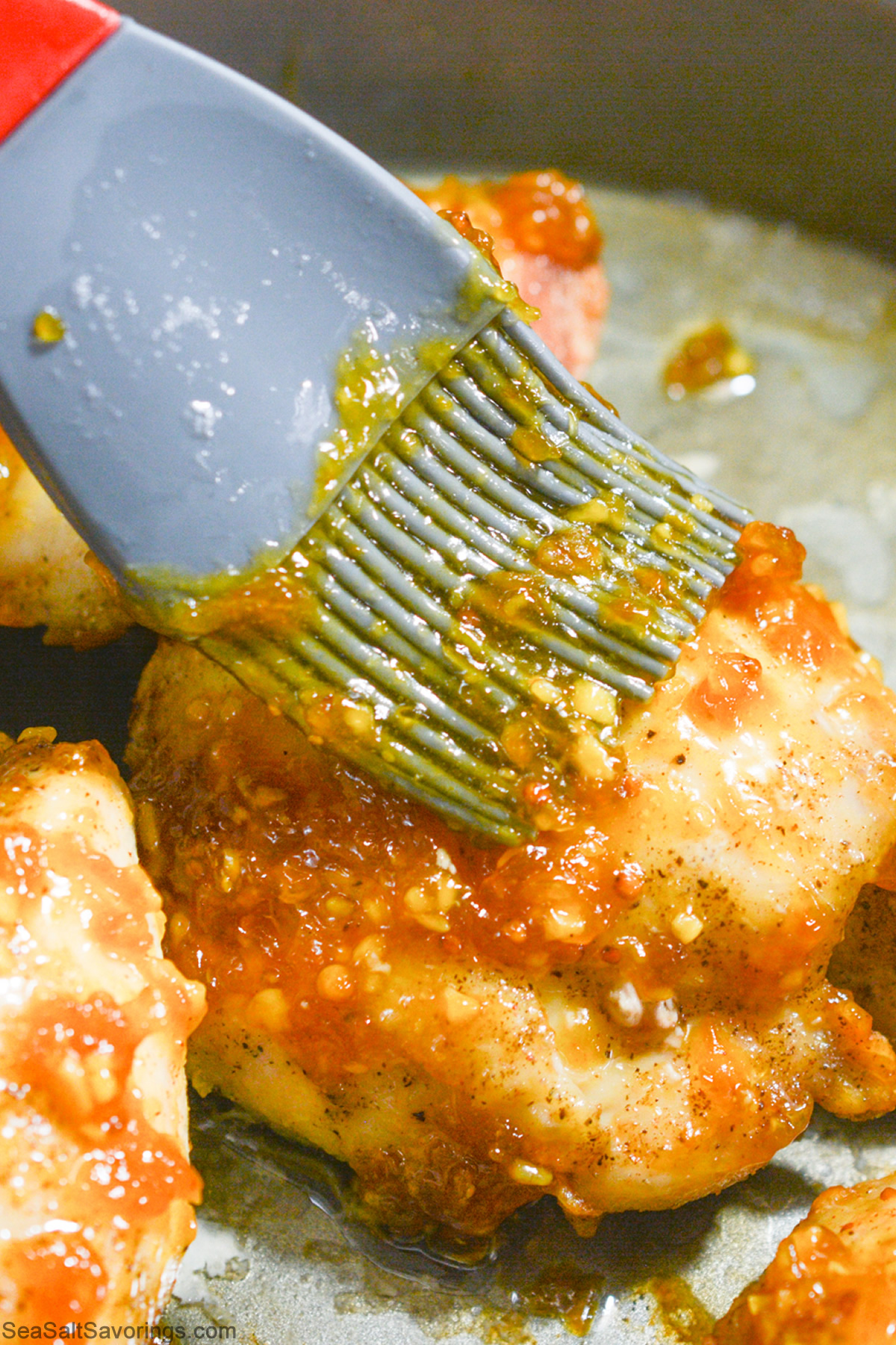 brushing chicken thigh with apricot glaze