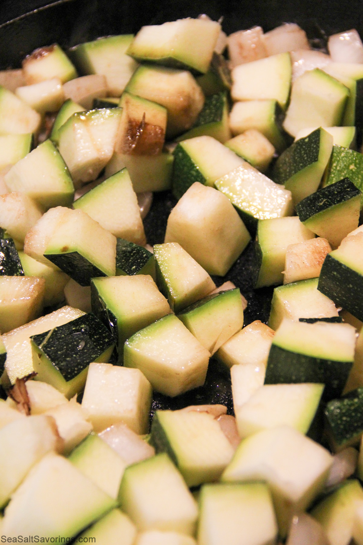 onion and zucchini frying in pan