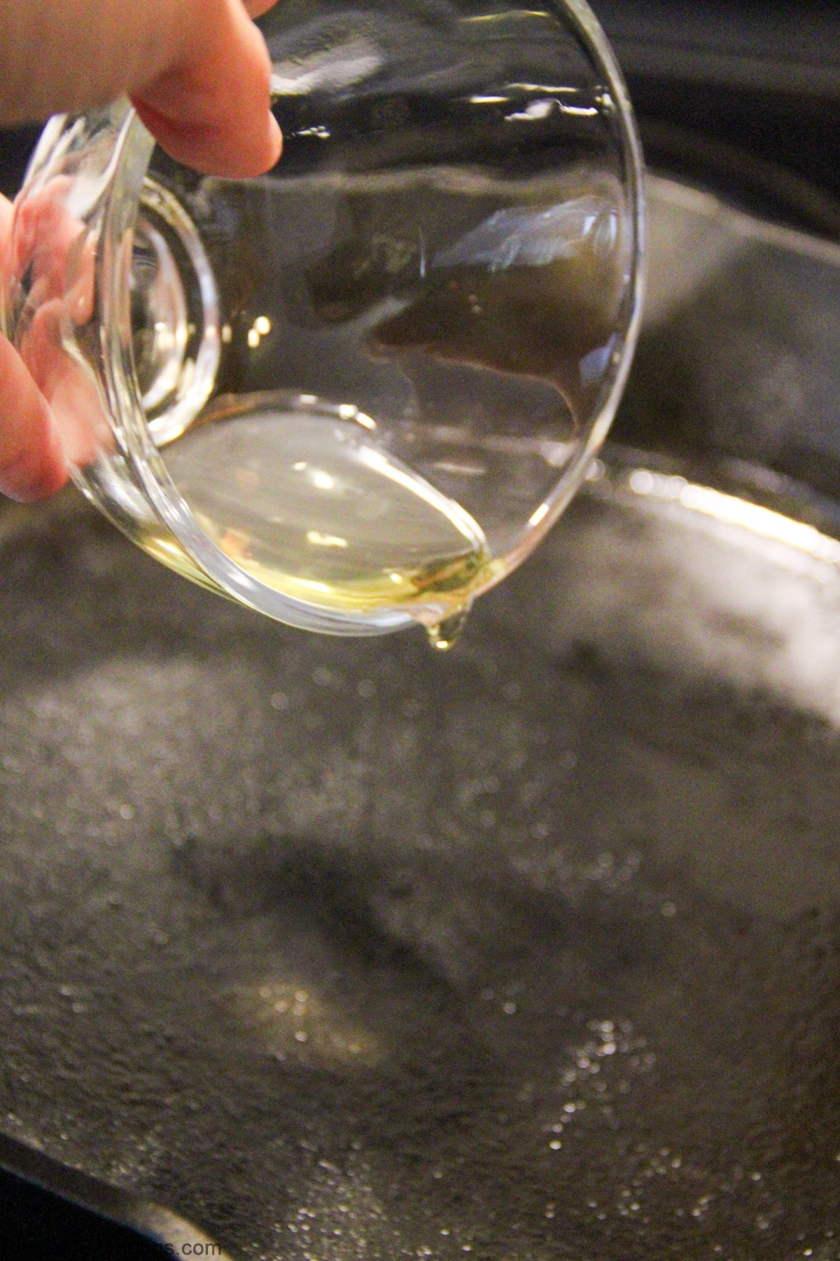 pouring oil in a cast iron pan