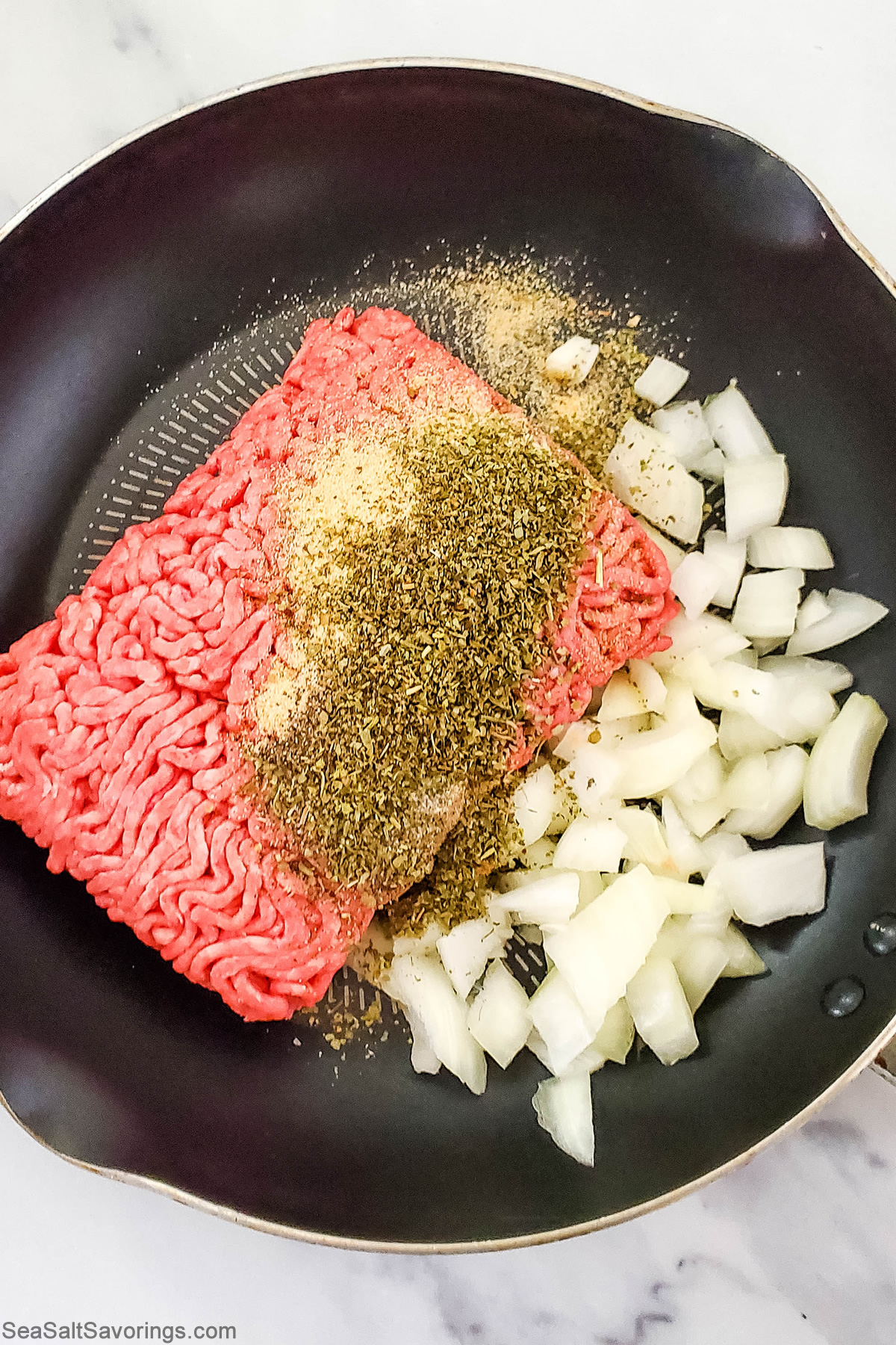 spaghetti sauce ingredients placed in a pan raw