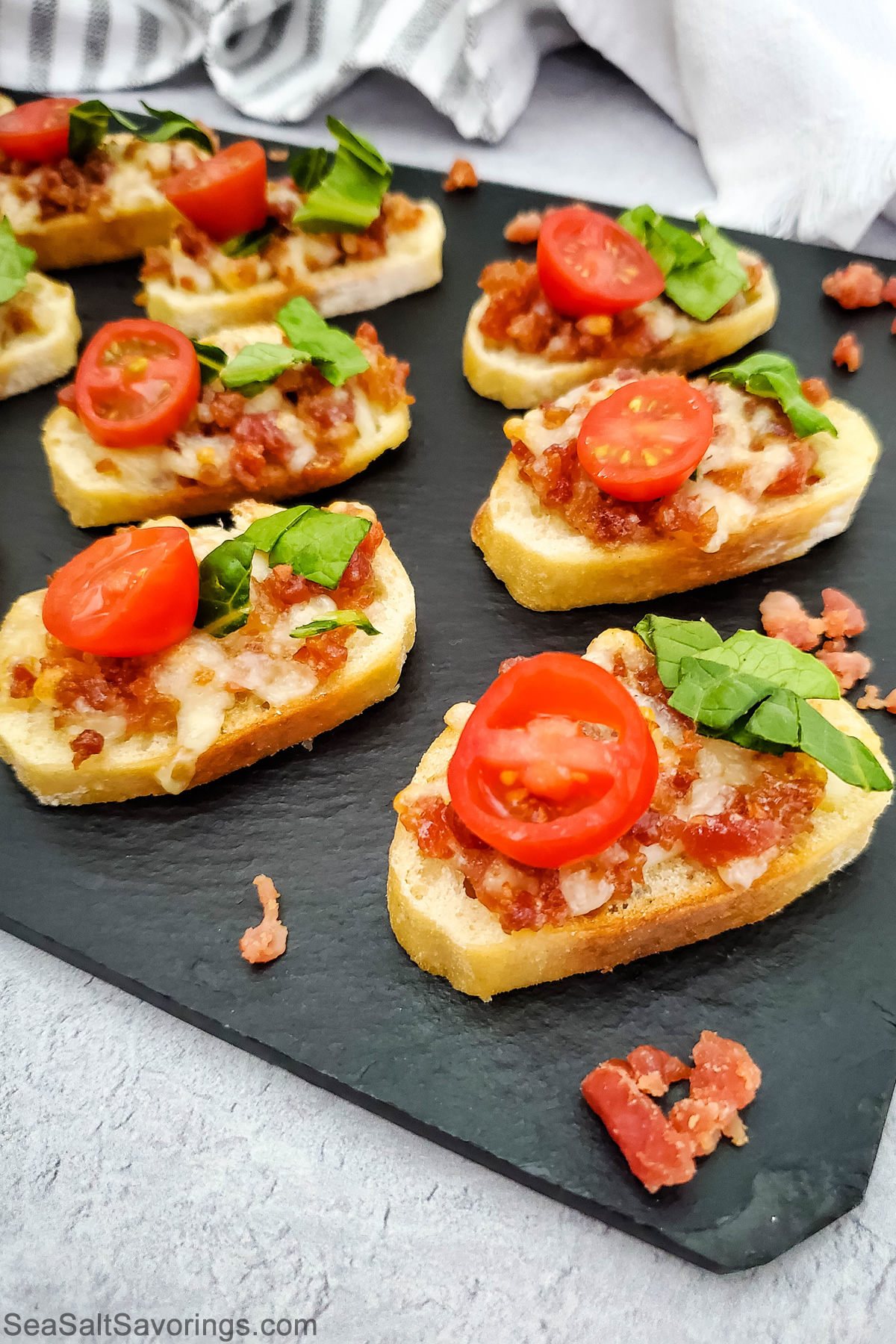 crostinis with bacon lettuce and tomato on top and melted cheese