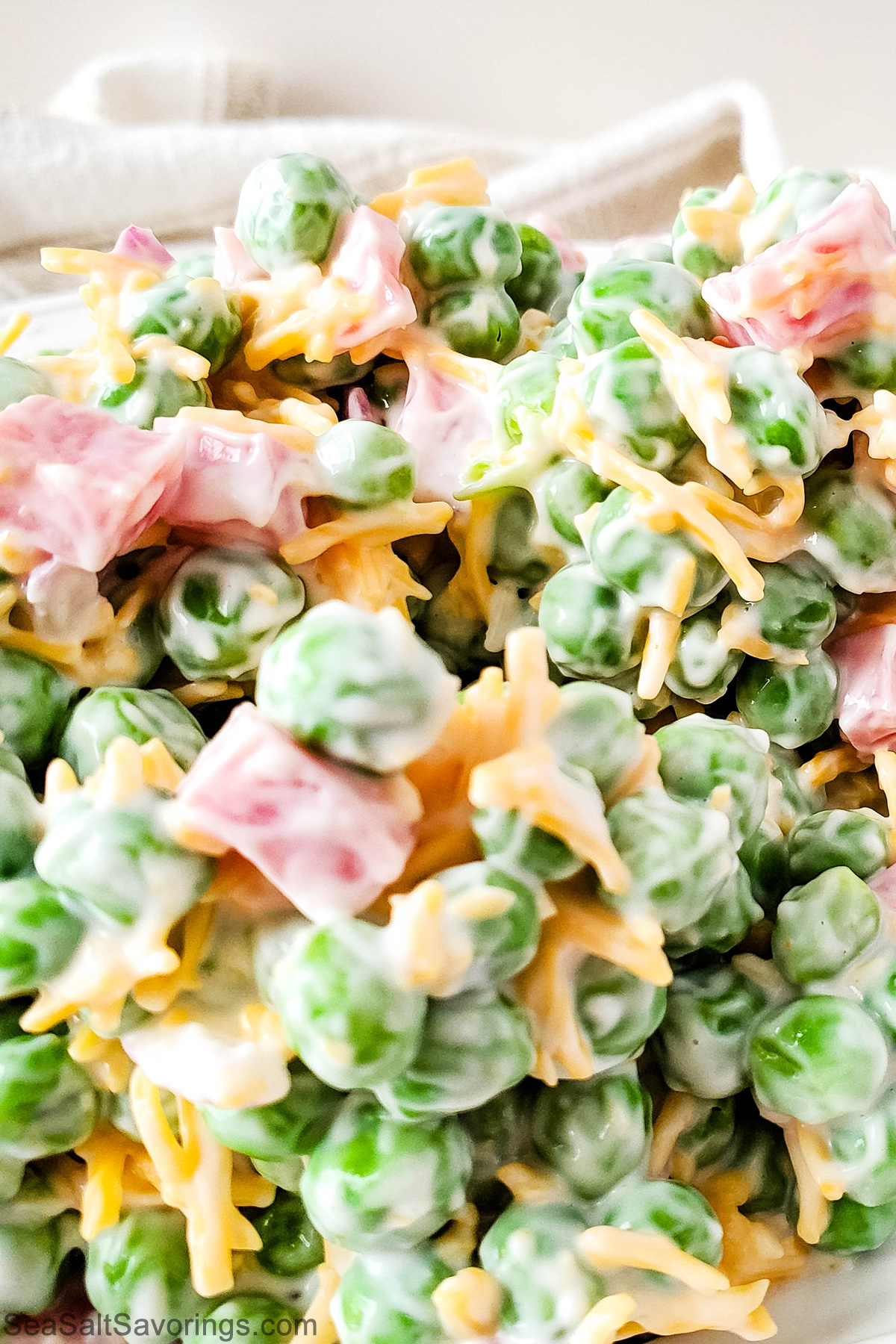 Cold Ham and Pea Salad served in a bowl, featuring diced ham, sweet peas, cheddar cheese, and a creamy dressing