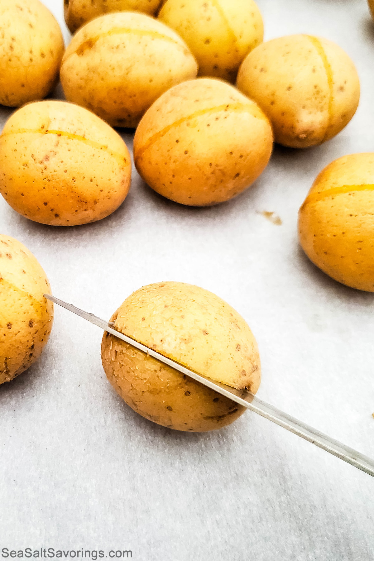 slicing mini baked potatoes