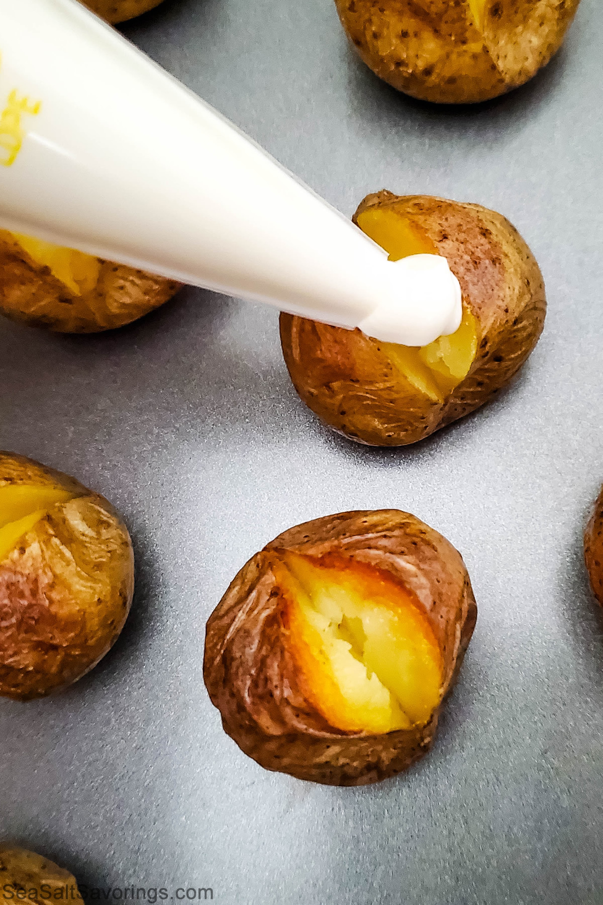 filling baked potatoes with sour cream