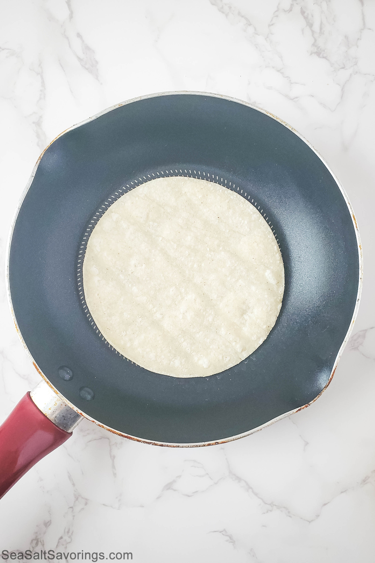 tortilla being warmed in a pan