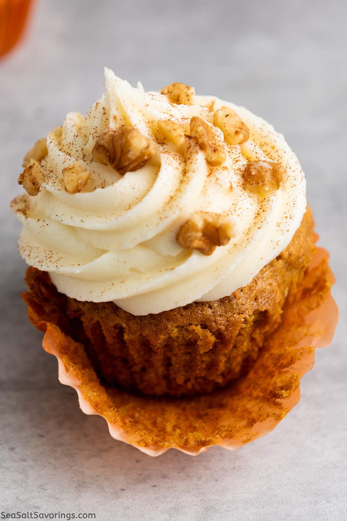 close up view of a carrot cupcake with the wrapper peeled back