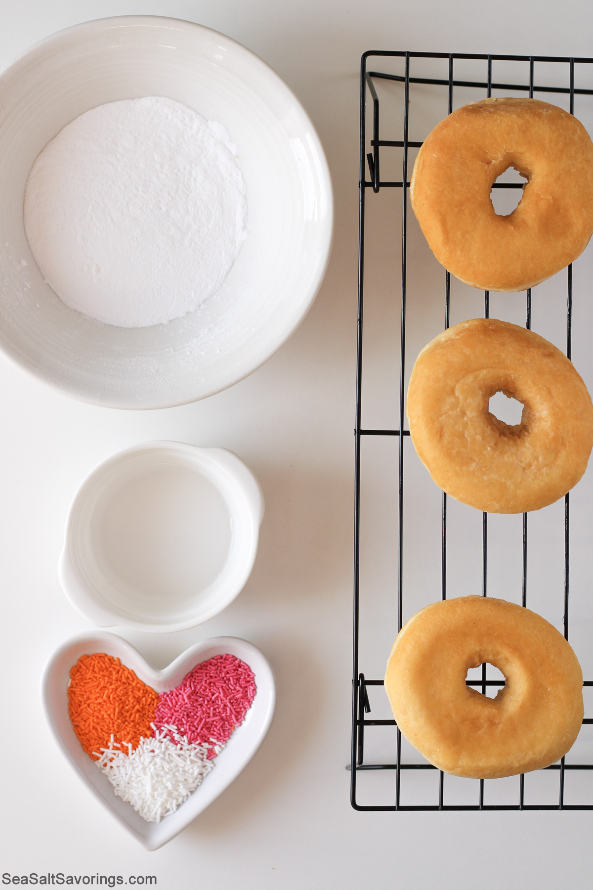 cooked plain donuts on a drying rack next to ingredients
