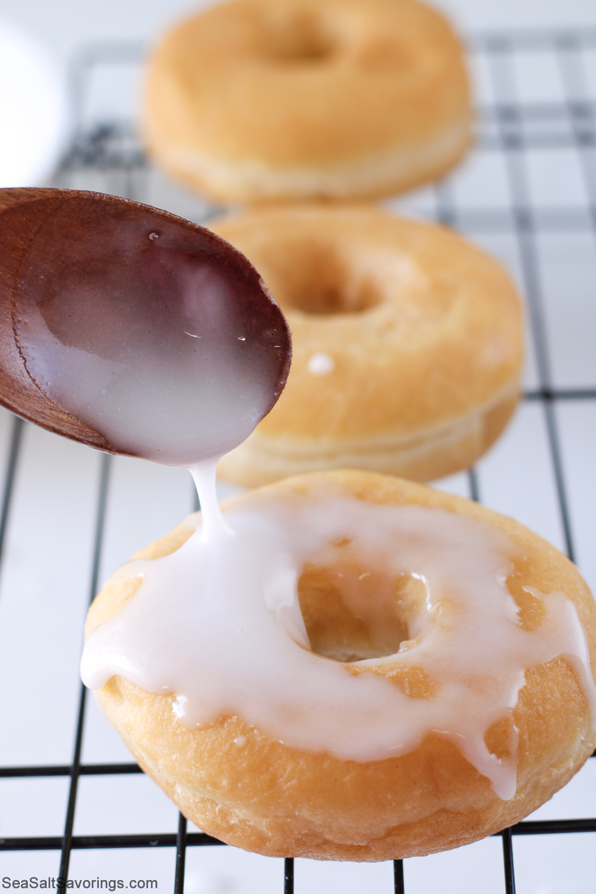 drizzling sugar glaze on top of donuts