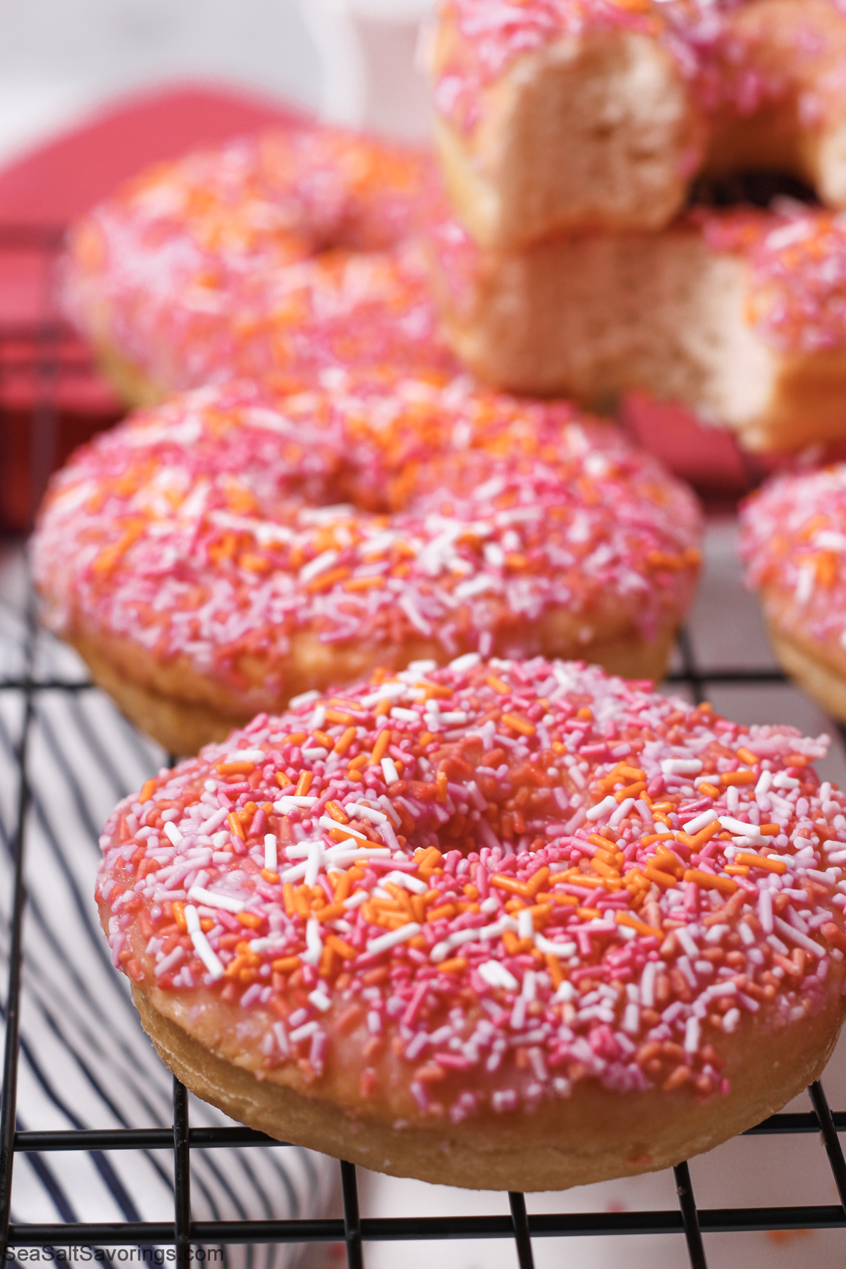 close up view of freshly baked donuts with colorful sprinkles on top