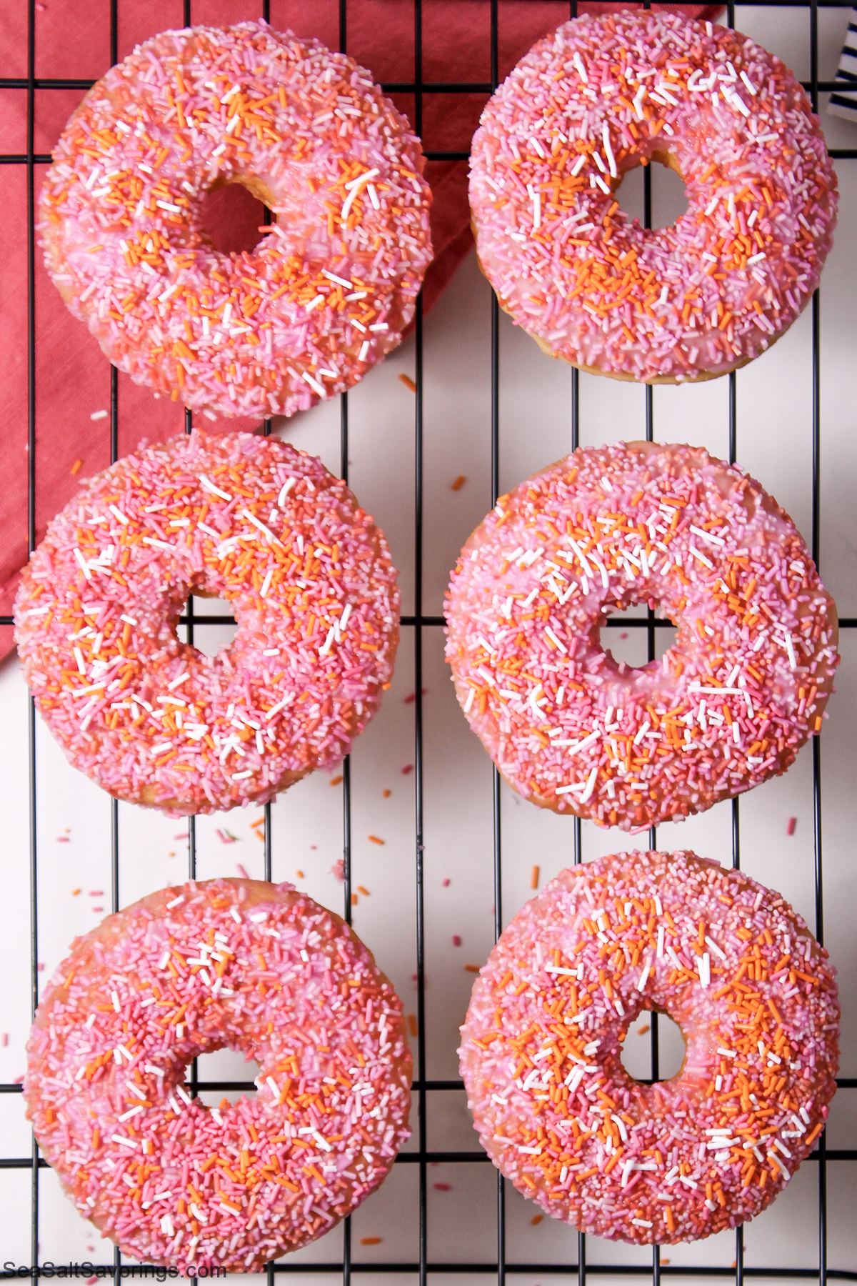 donuts with sprinkles on a drying rack
