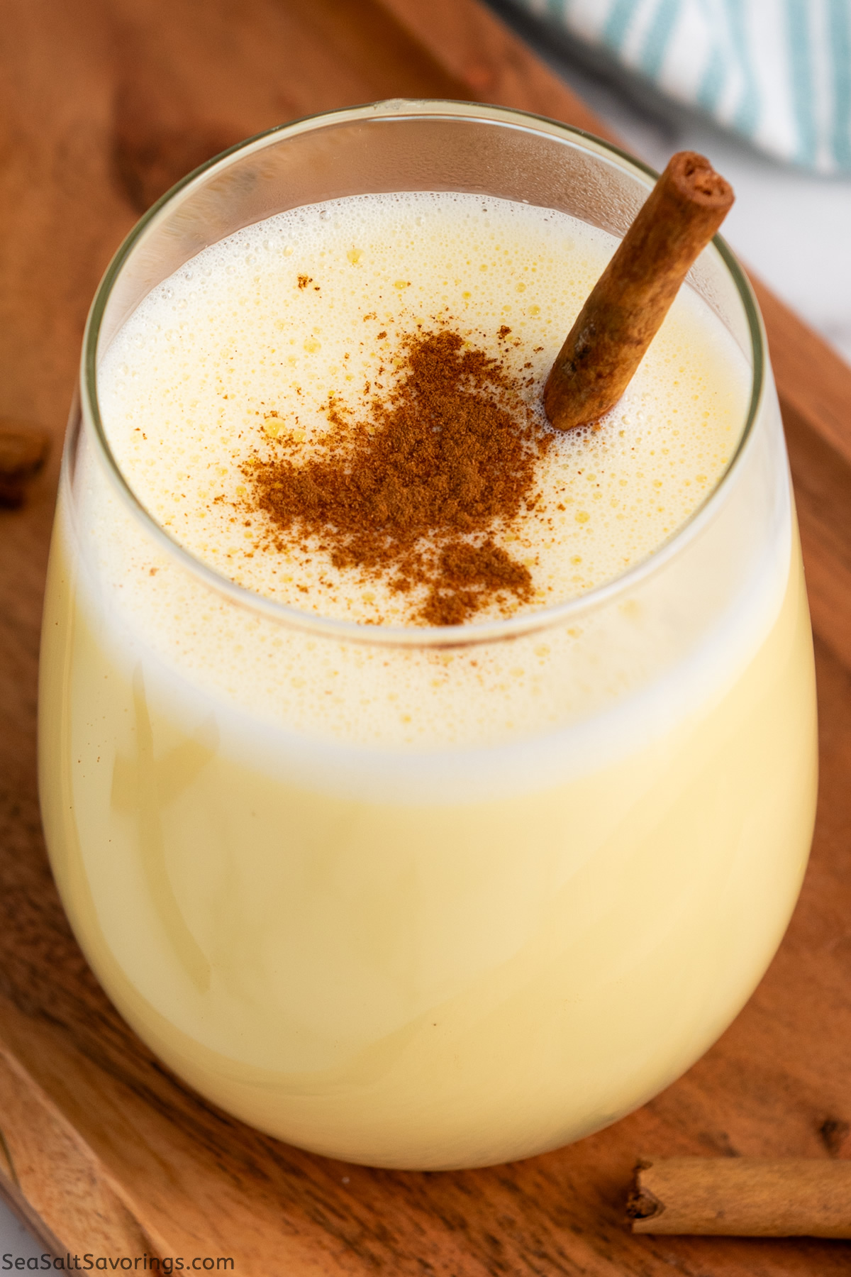 close up view of a glass of eggnog with cinnamon on top