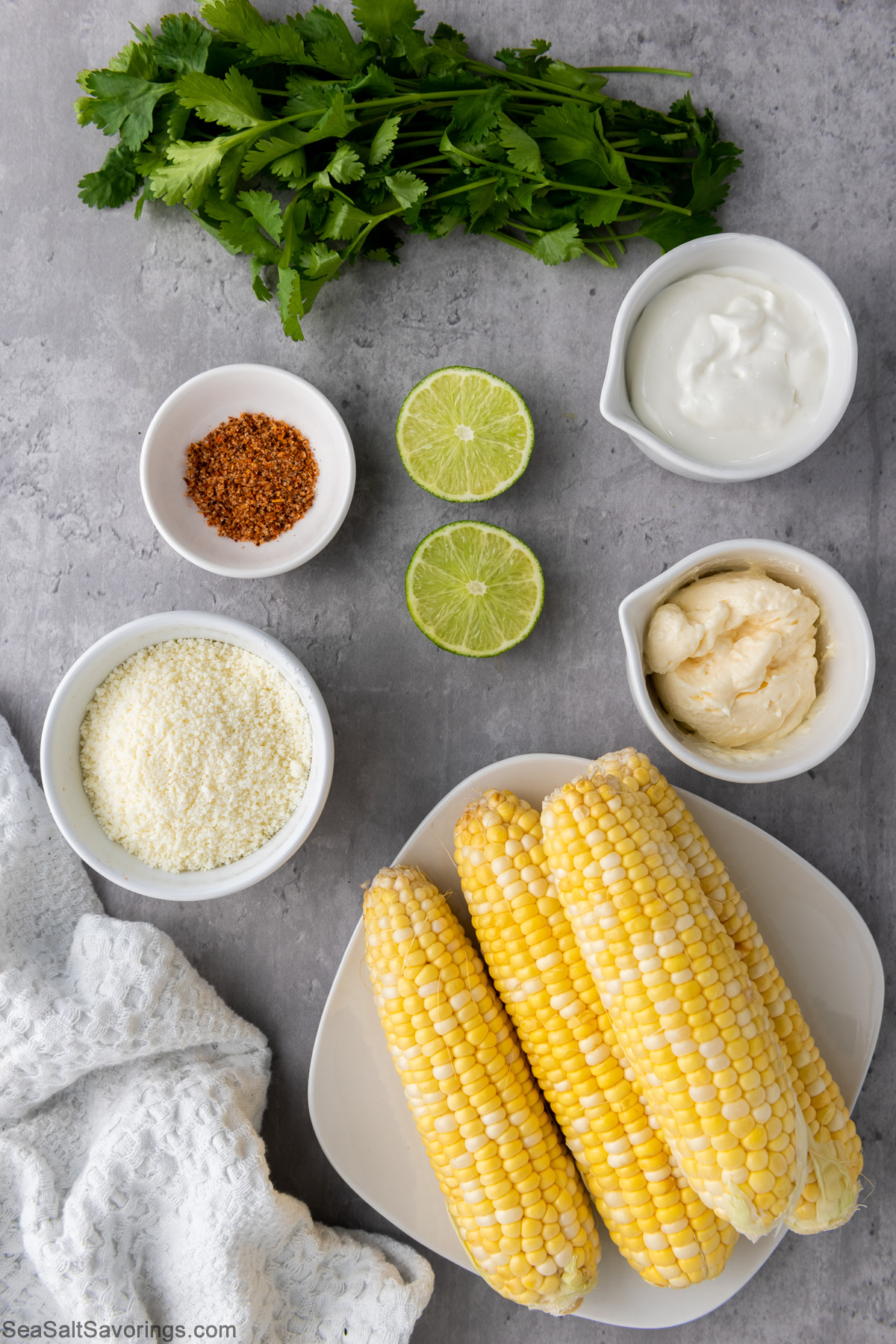 plate of corn cobs and seasoning and toppings