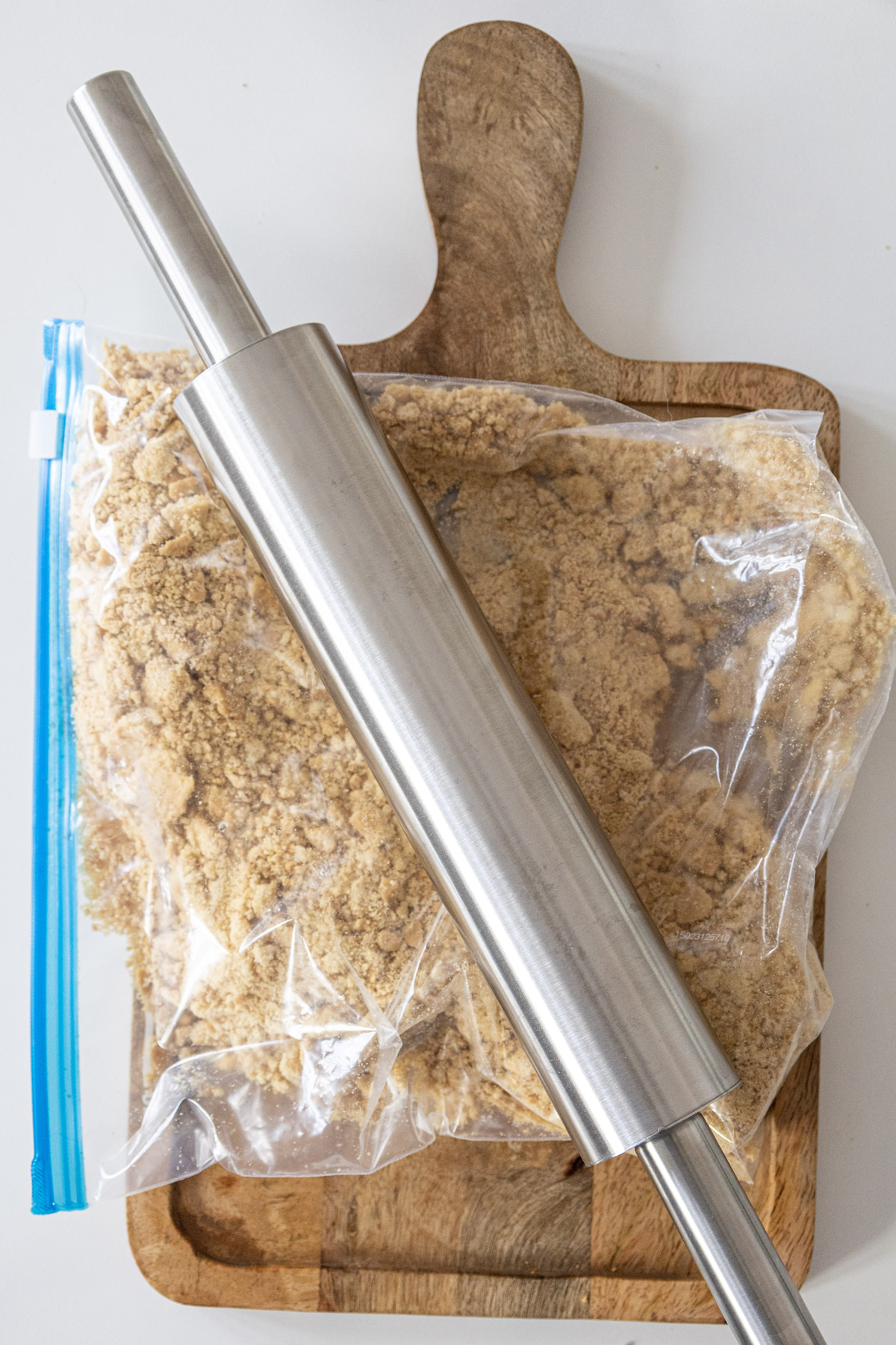 rolling pin on top of a baggie of crushed crackers
