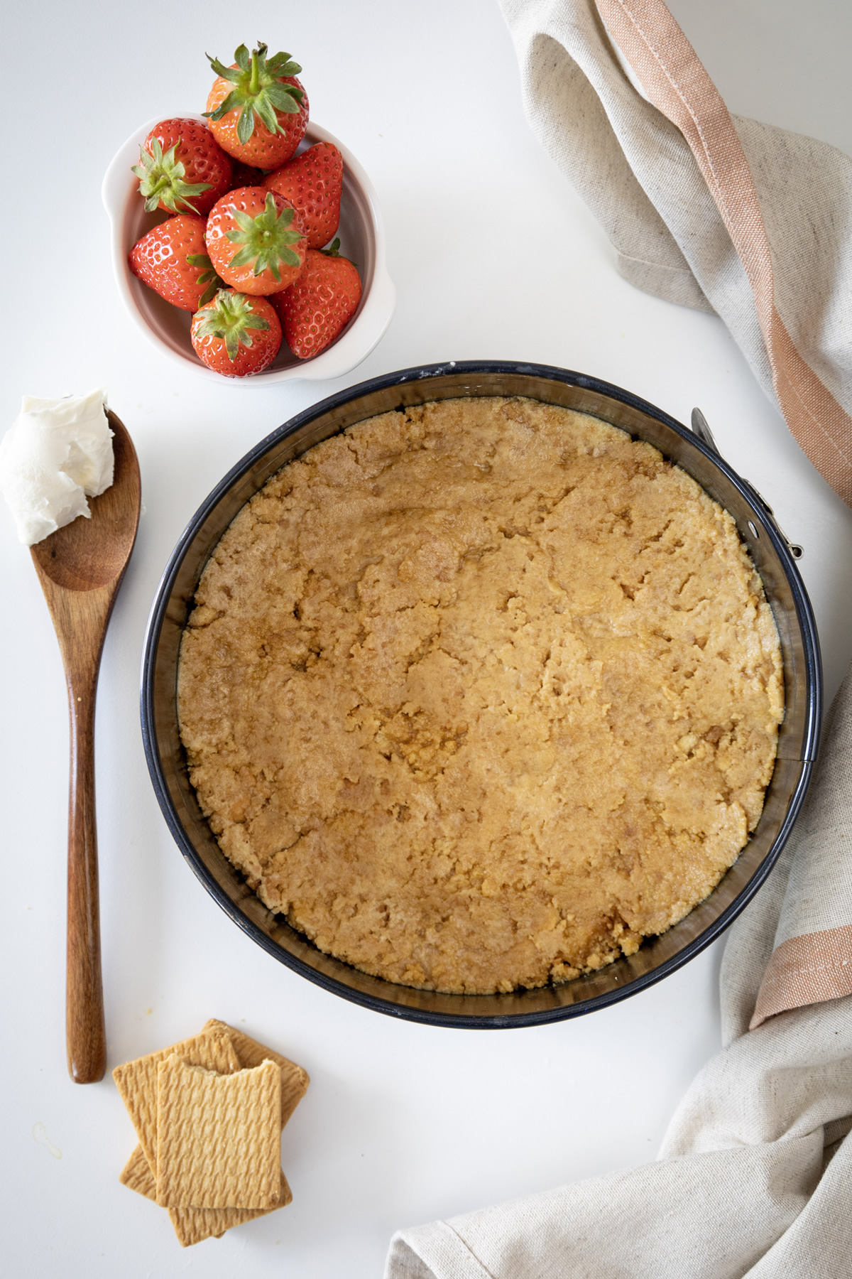 a cake pan with graham cracker crust added to bottom