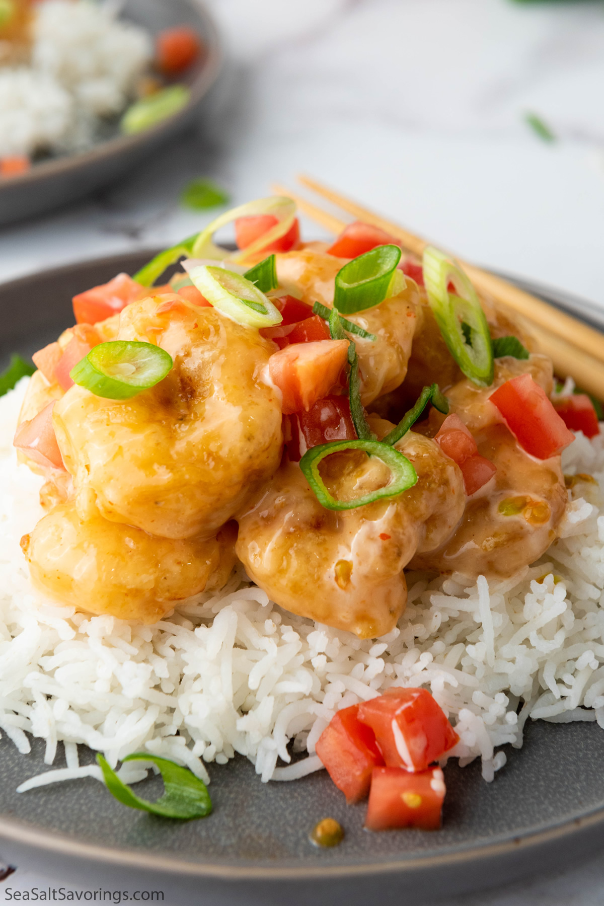 Bang Bang Shrimp over white rice in a bowl, showcasing the crispy shrimp topped with spicy, creamy sauce