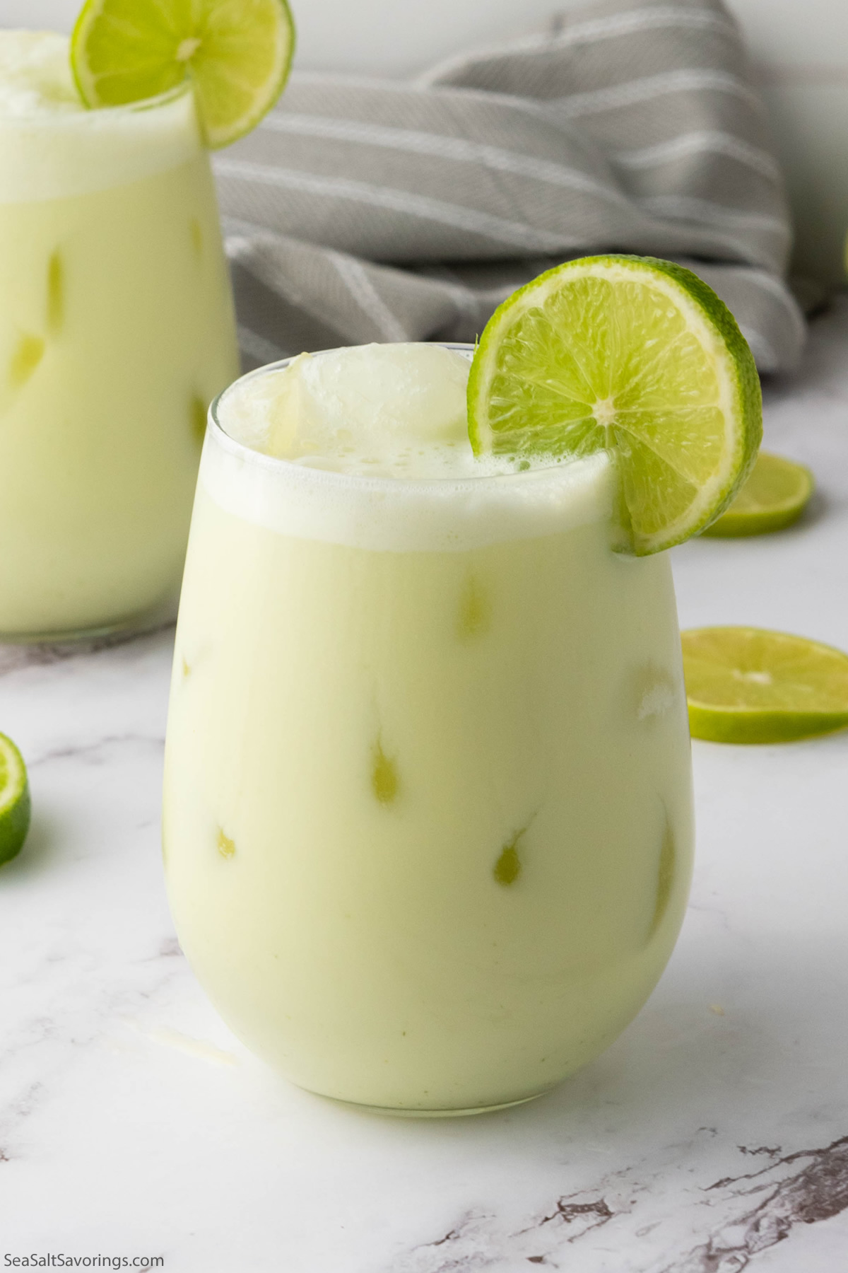 glass of limeade with a lime garnish on the rim of the glass