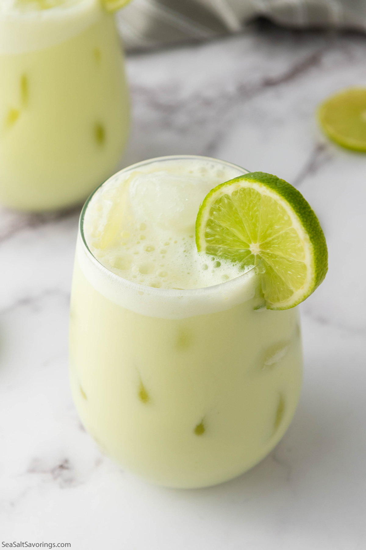 glass of limeade with a lime garnish on the rim of the glass