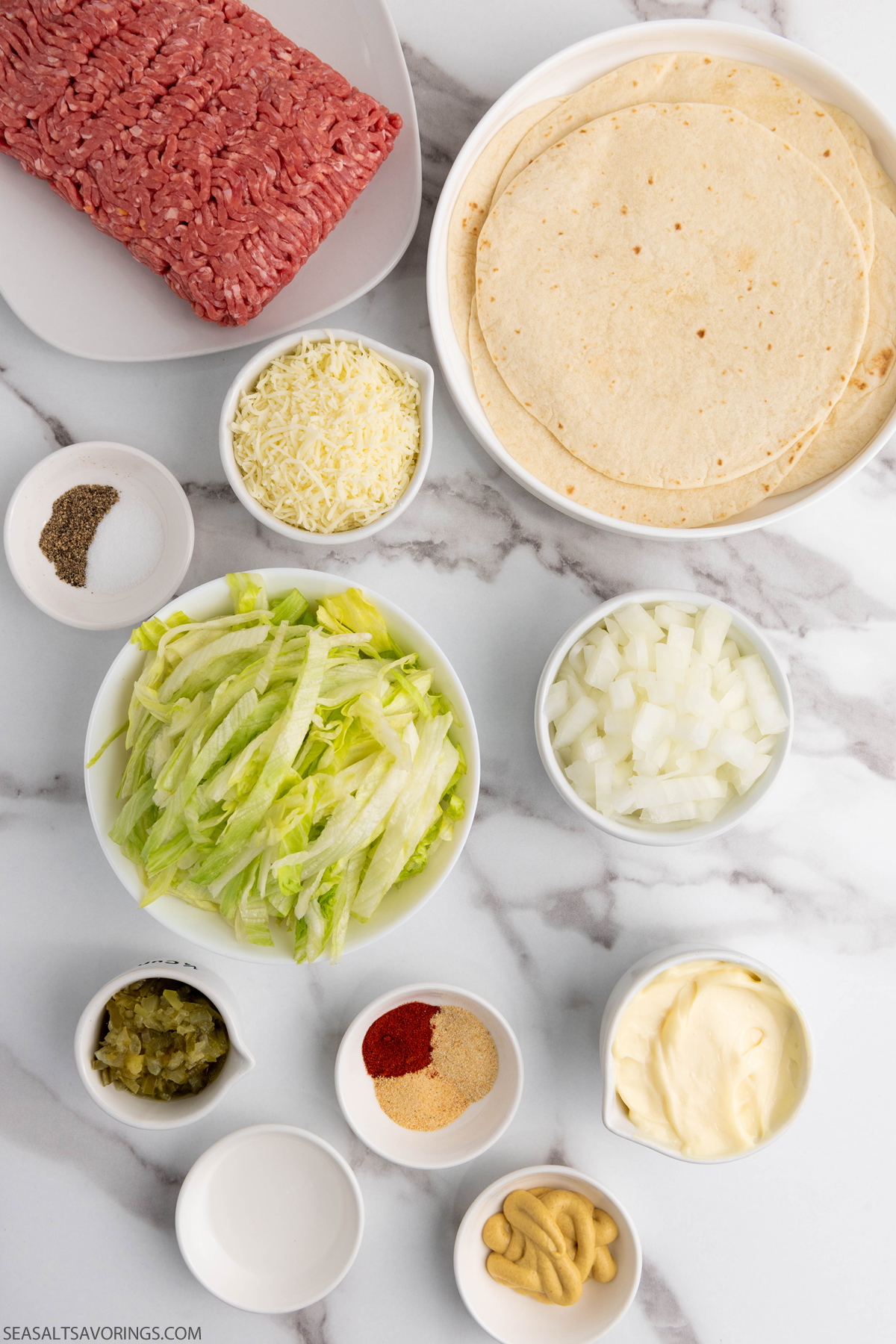 fresh ingredients for tacos such as tortillas, ground beef, and toppings