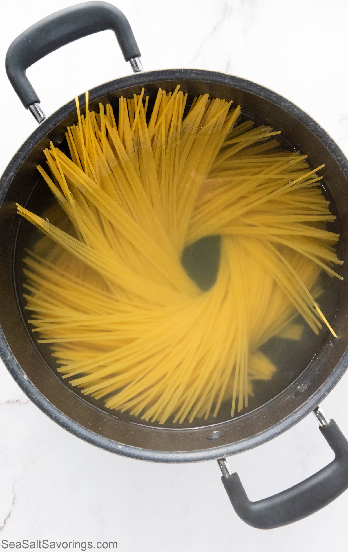 bowling spaghetti noodles in a pot of water