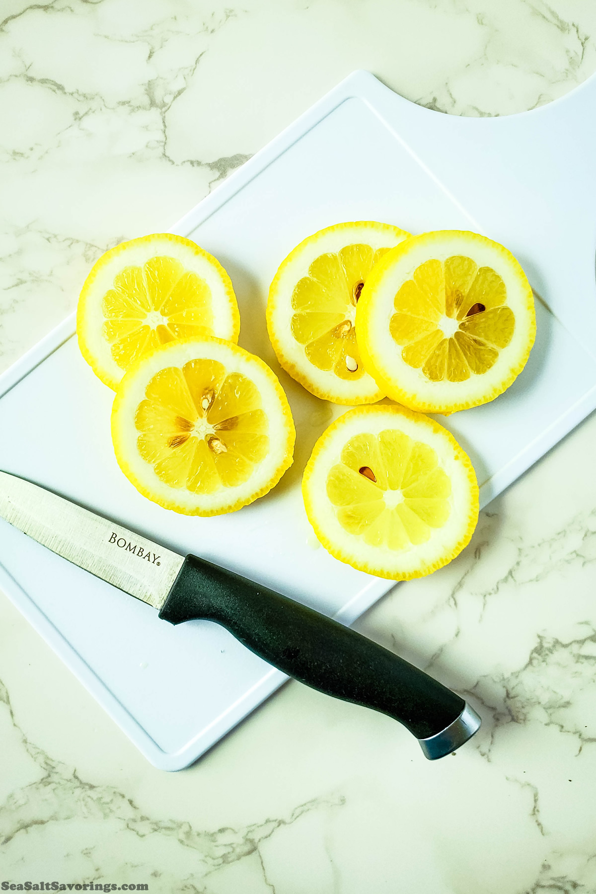 slicing lemon on a cutting board