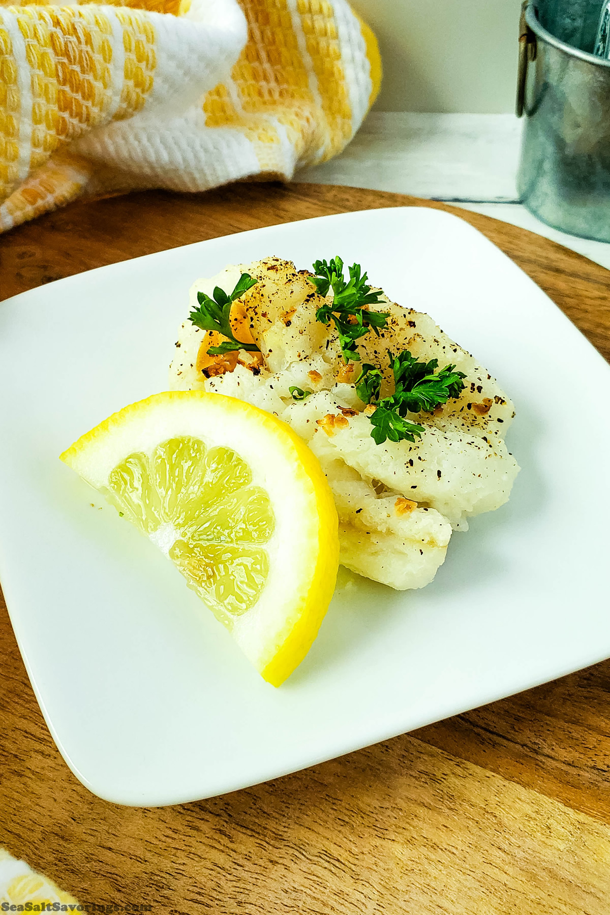 plate with freshly air fried cod with lemon wedge